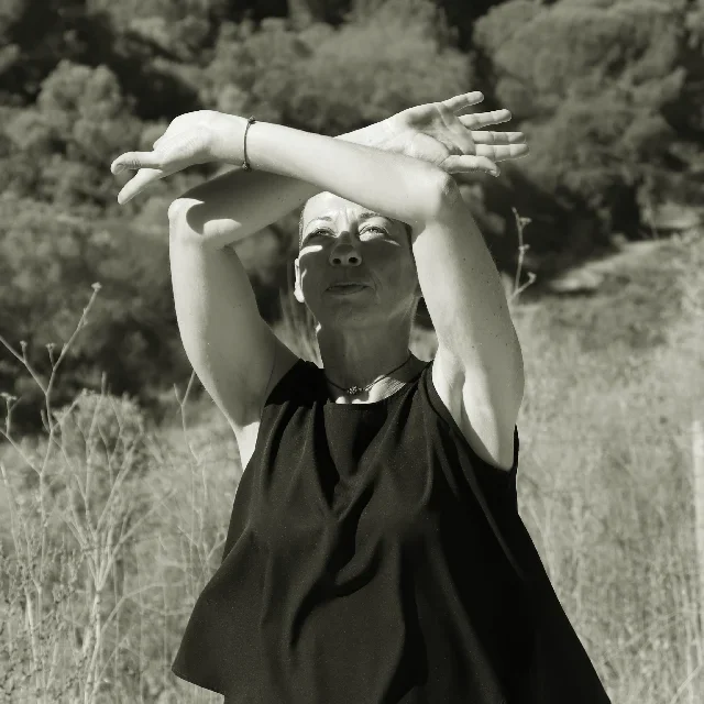 Vanda a fazer movimento de Chi Kung, a cruzar os braços em frente ao rosto para fazer um arco acima da cabeça. Movimento de afastar as nuvens.