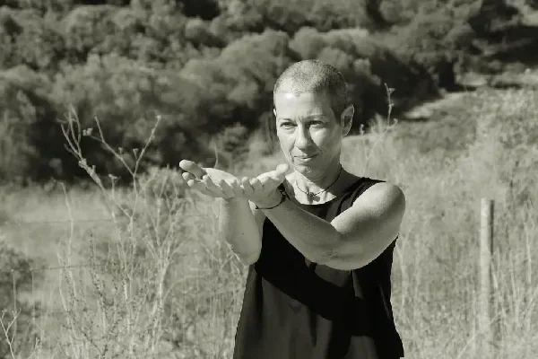 Vanda com os braços esticados em frente ao corpo, com as palmas para o céu, em posição receptiva.