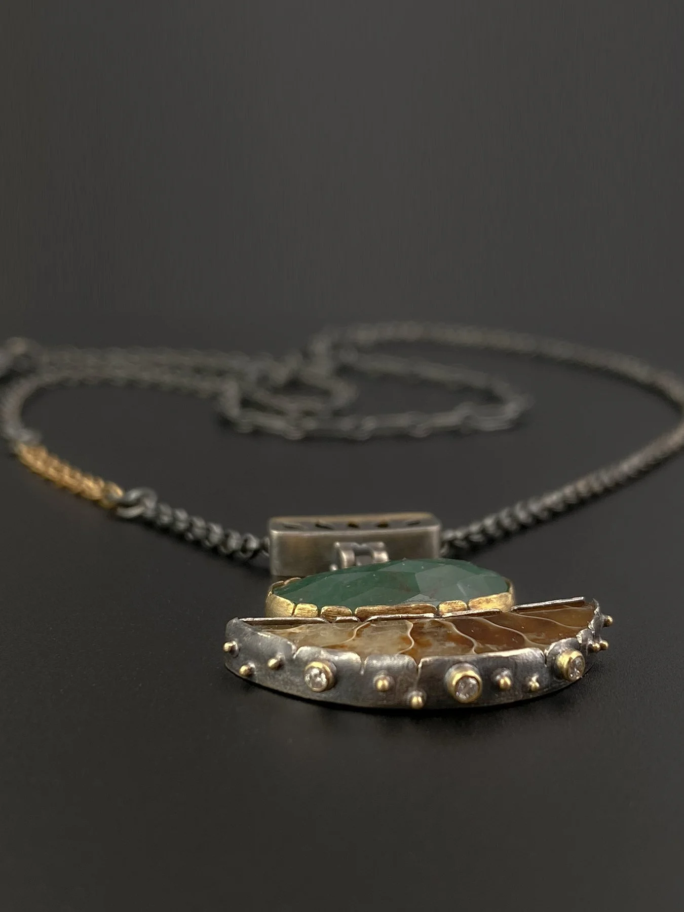 Detail shot of a 400-million-year-old chambered ammonite fossil slice, highlighted by three delicate 2mm diamond accents along the bottom edge of the silver setting.