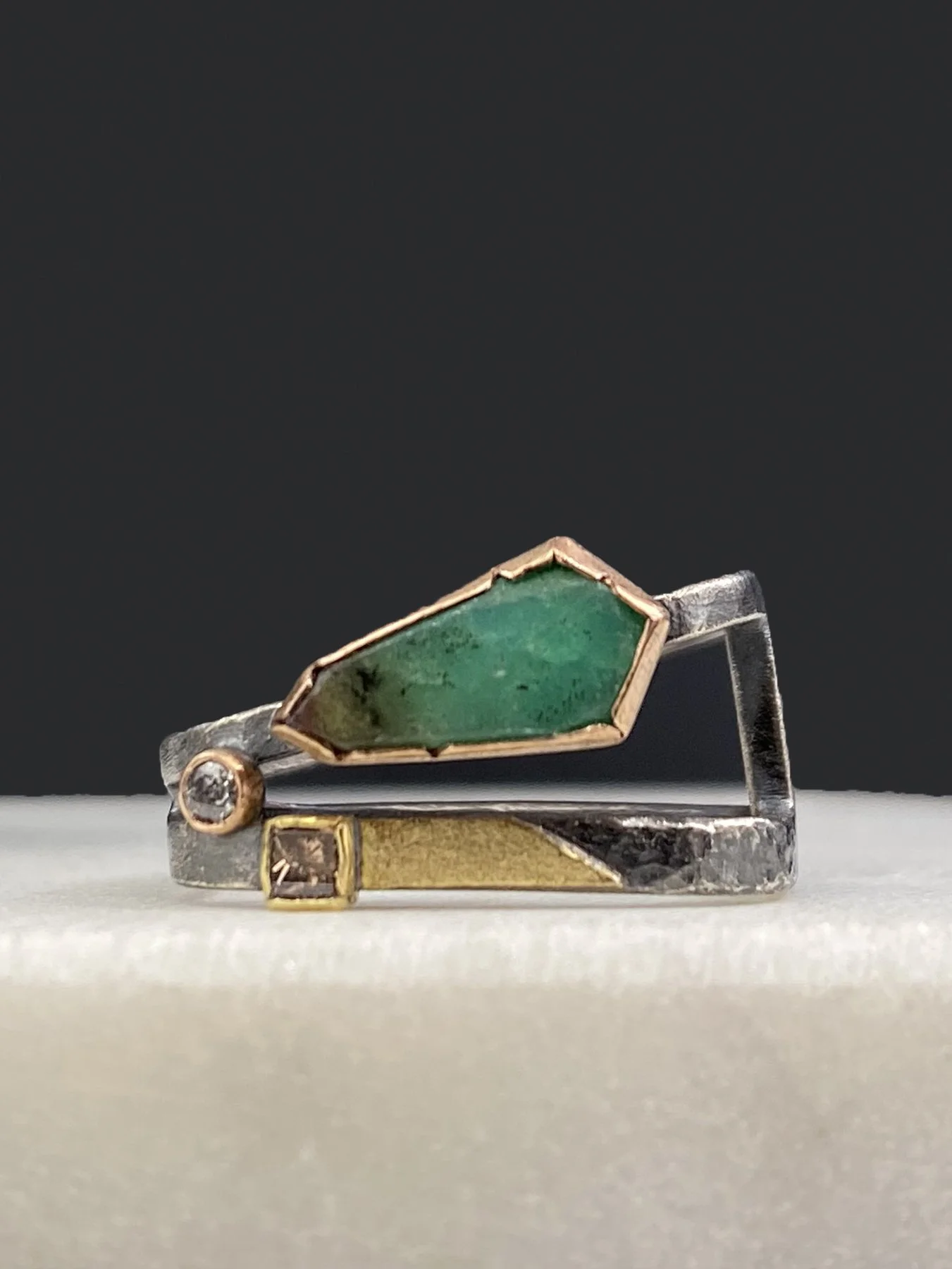 Front view of an architectural angled square ring featuring a custom-cut green chrysoprase and diamond accents, crafted in oxidized silver, 14k, and 18k gold.
