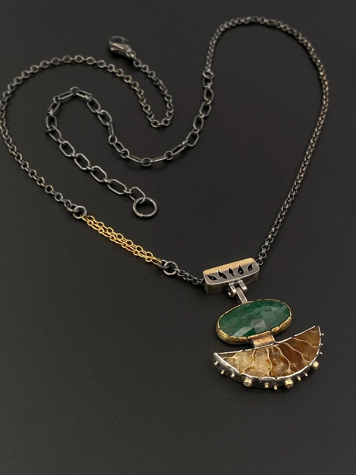 Close-up of the pendant's custom geometric articulated bail with pierced detailing, hanging from an adjustable mixed-link oxidized sterling silver and 18k gold chain.