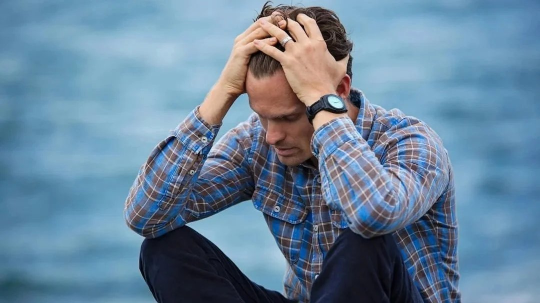 Man holding his head in his hands