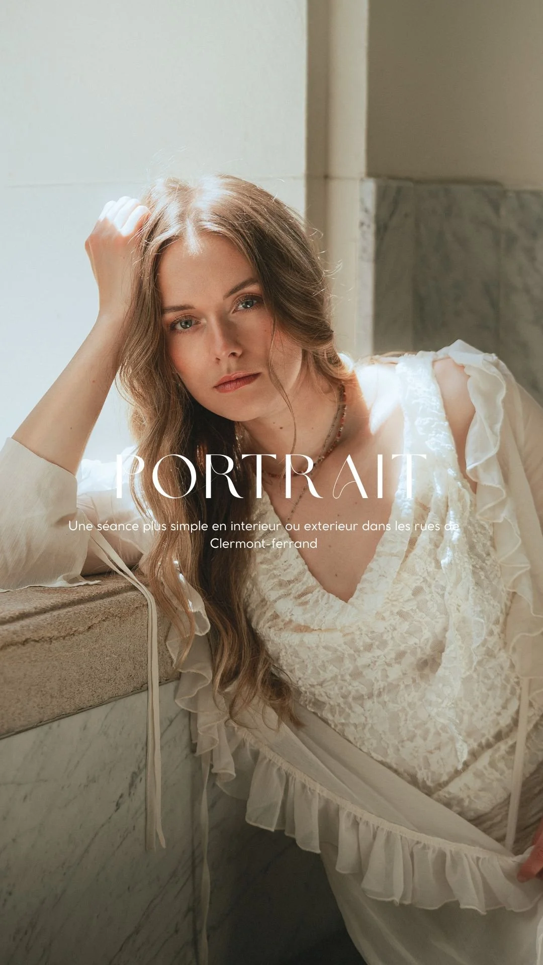 Une jeune femme aux cheveux longs bruns regarde l'objectif, assise dans une pièce lumineuse avec des murs en pierre et un comptoir.