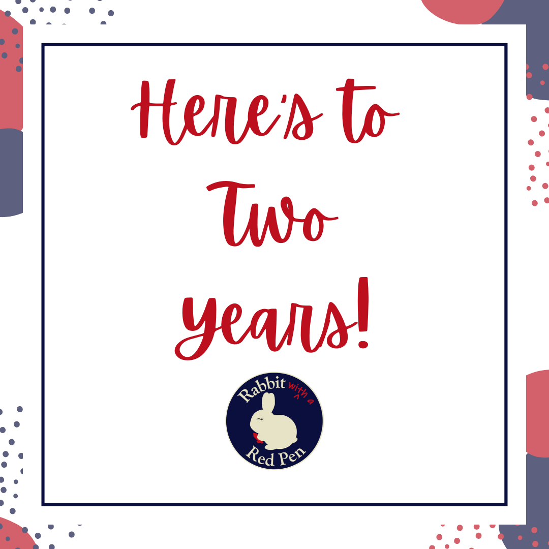 A red, white, gray, and blue graphic that says "Here’s to Two Years!"