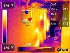 Thermal image showing a room with significant heat variation; warm areas in yellow and white, cooler in purple and blue. Temperature readings indicate a hot spot at 82.2°F and cooler areas as low as 67°F, with measured temperatures on the wall at aro