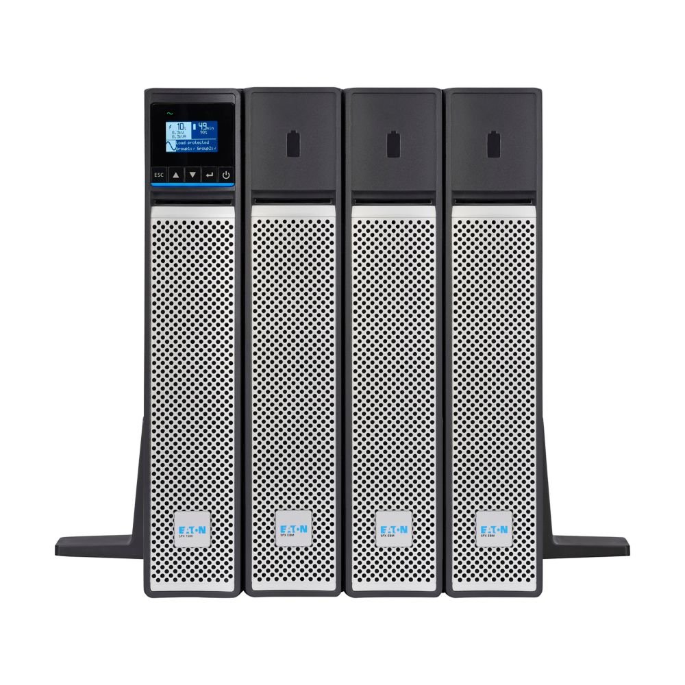 A row of four industrial uninterruptible power supply (UPS) units with digital displays on a stand.