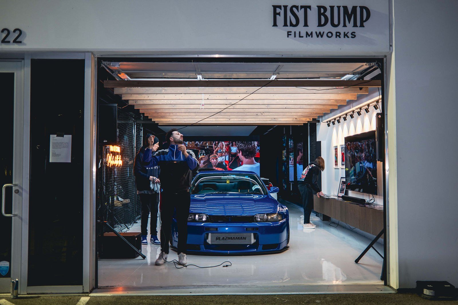 Car parked inside Fist Bump Studio, seen through the open front bay door