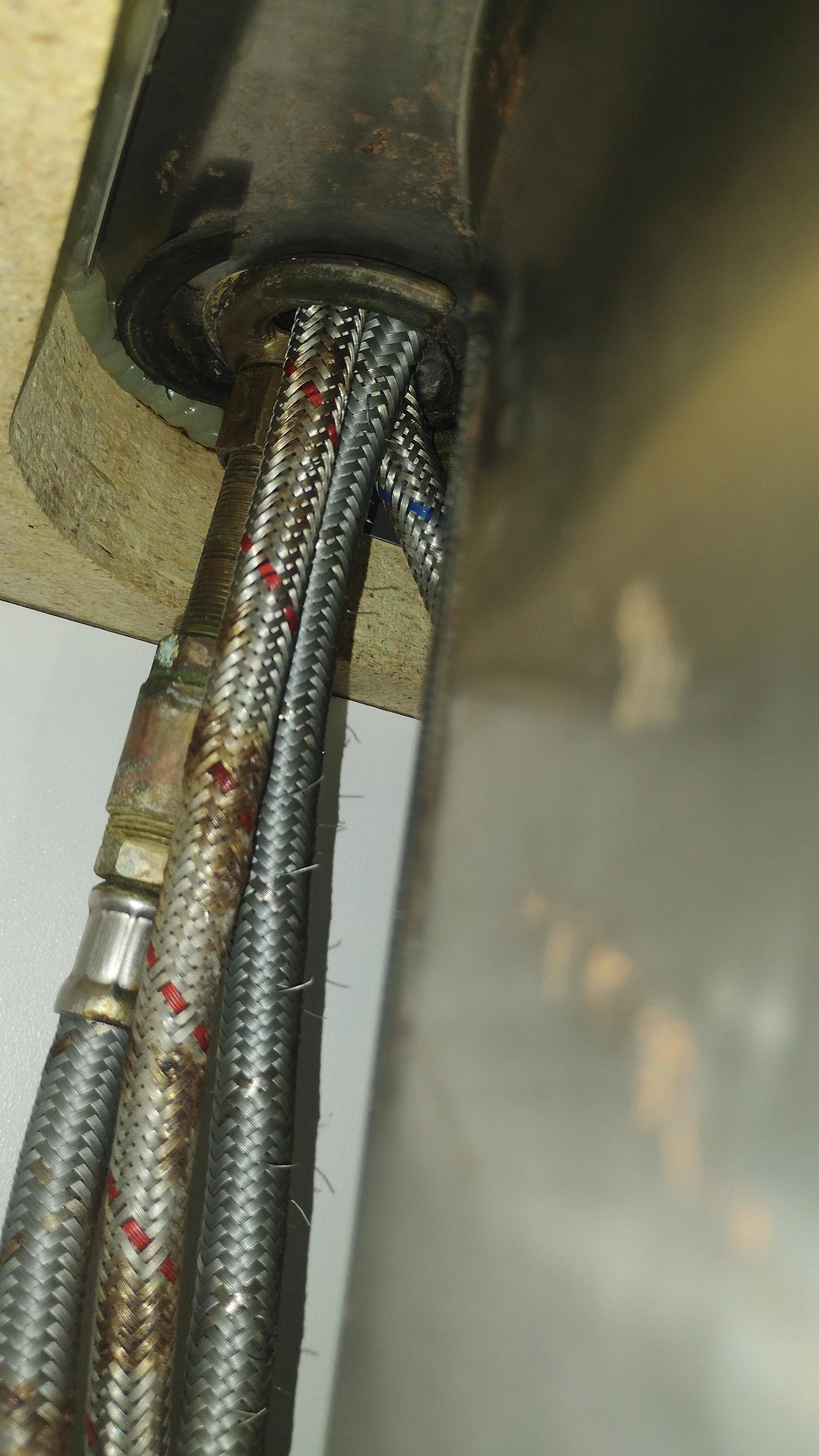 Corroded flexi hose under a kitchen sink, a leading cause of investment property water damage