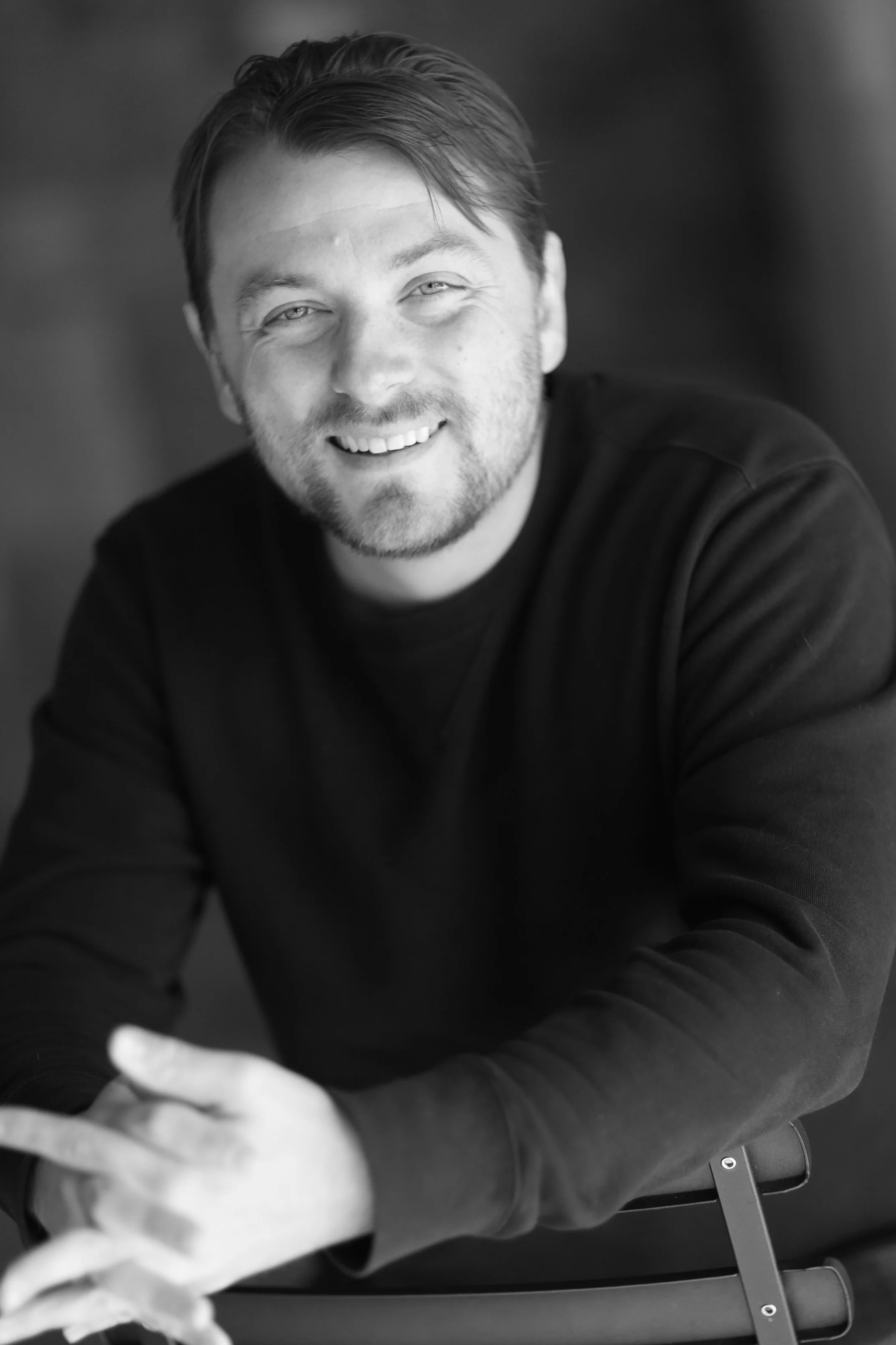Patrick Murney smiling in a studio headshot.