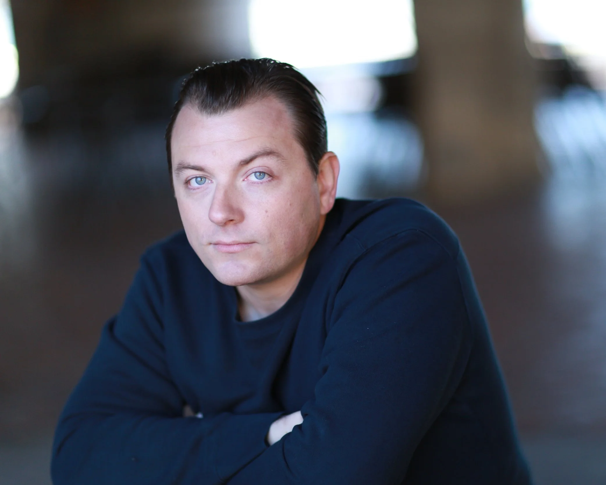 Patrick Murney seated with folded arms in a casual portrait.