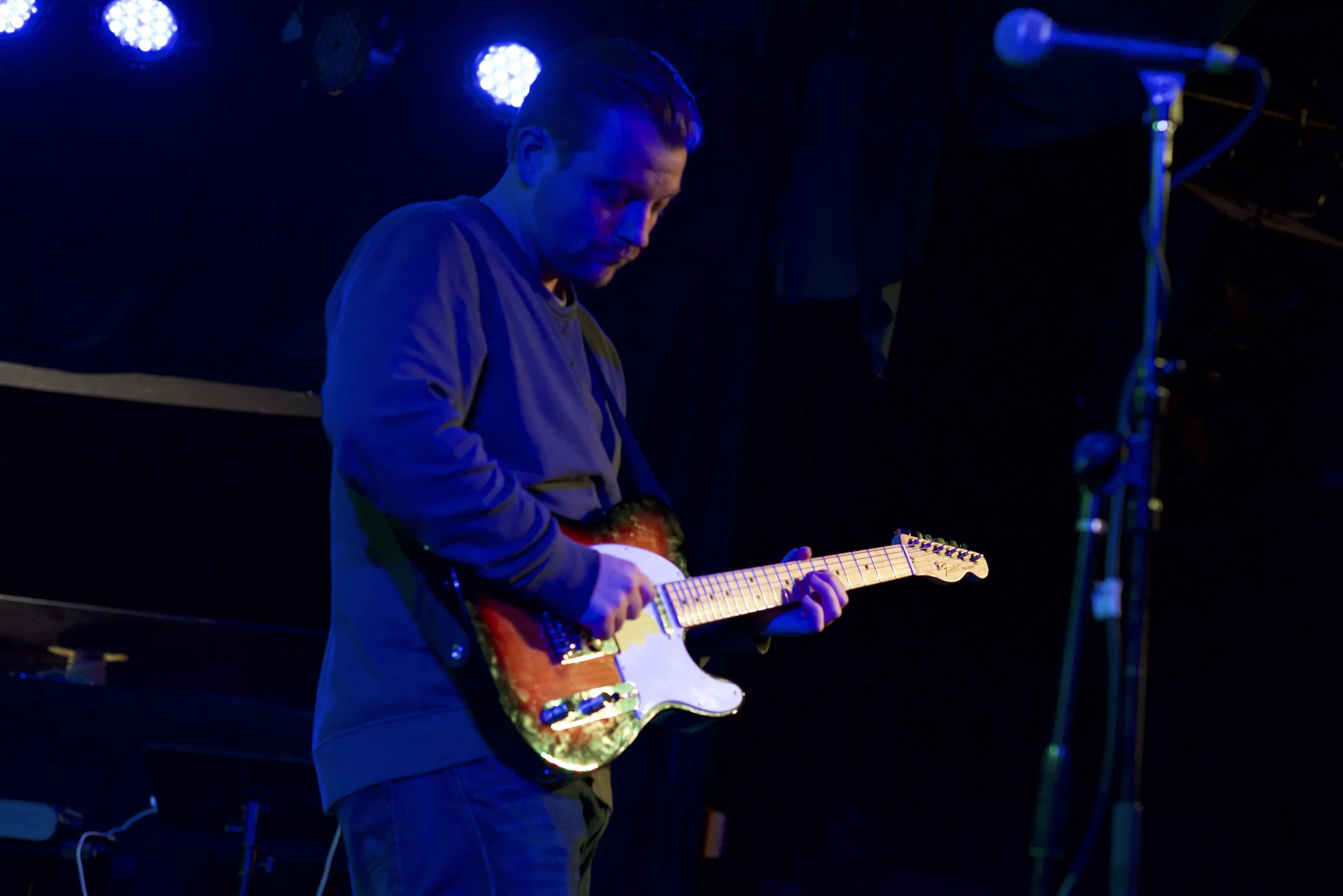 Patrick Murney playing electric guitar during a live performance.