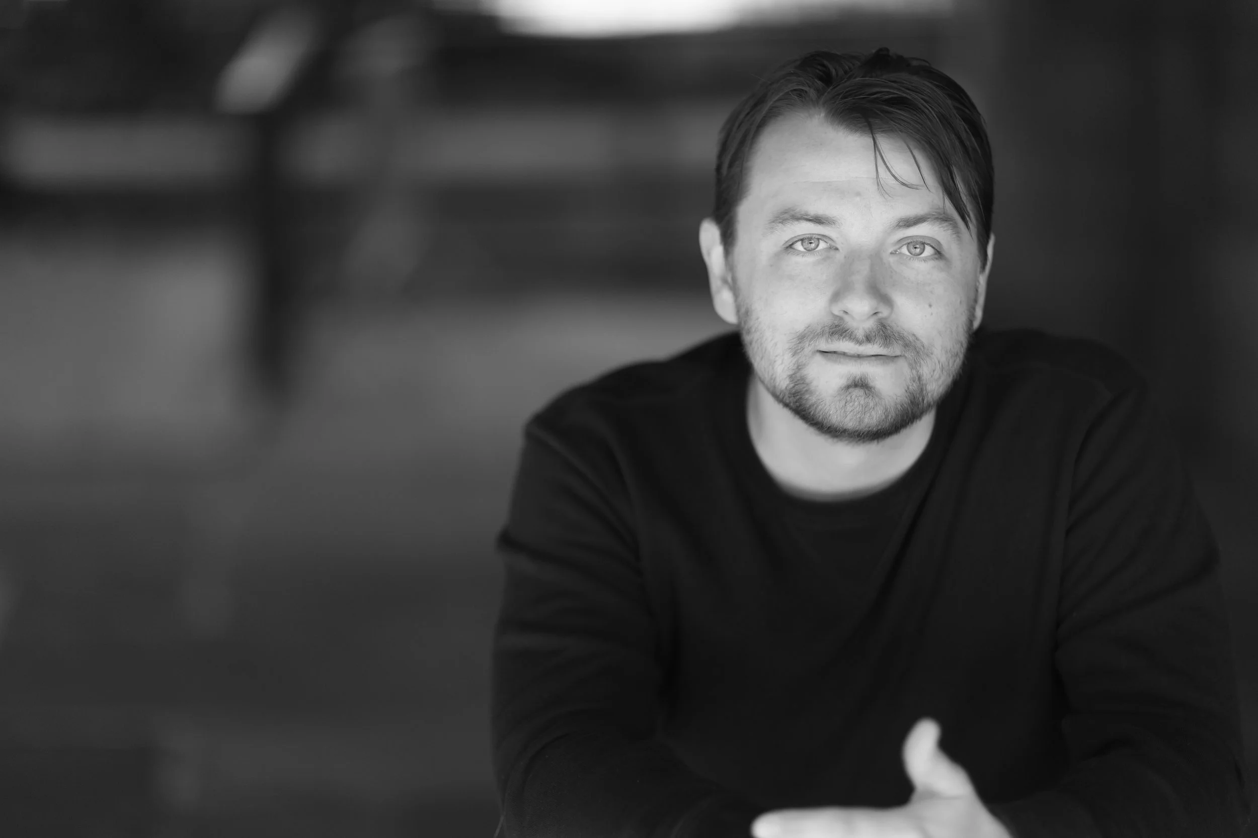 Black-and-white portrait of Patrick Murney smiling at the camera.