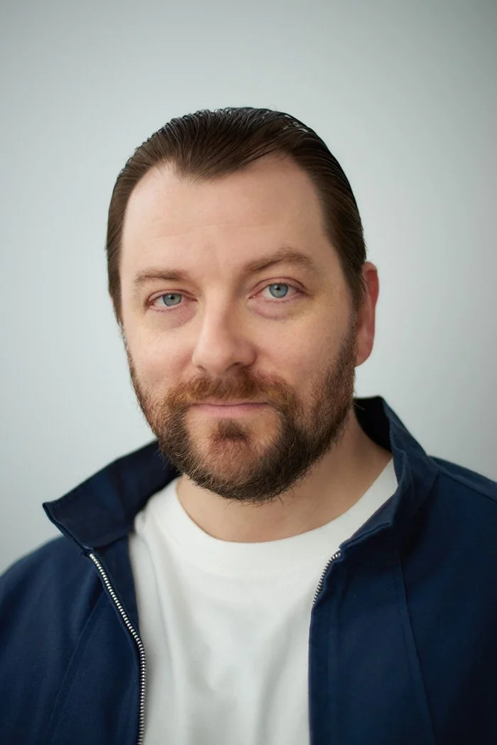 Patrick Murney portrait wearing a blue jacket indoors.