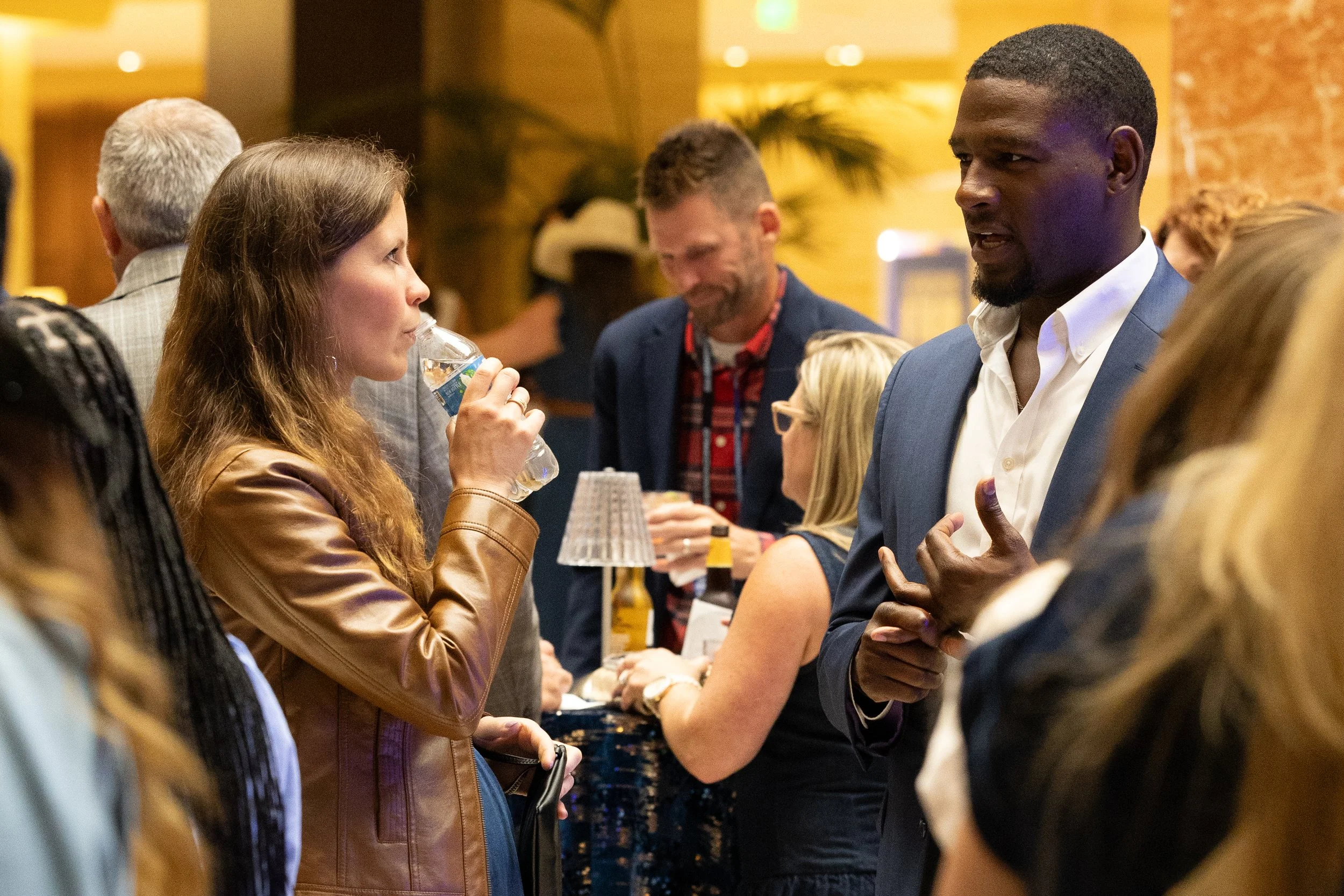Business professionals conversing and networking during a cocktail reception mixer at a corporate conference in Dallas-Fort Worth.