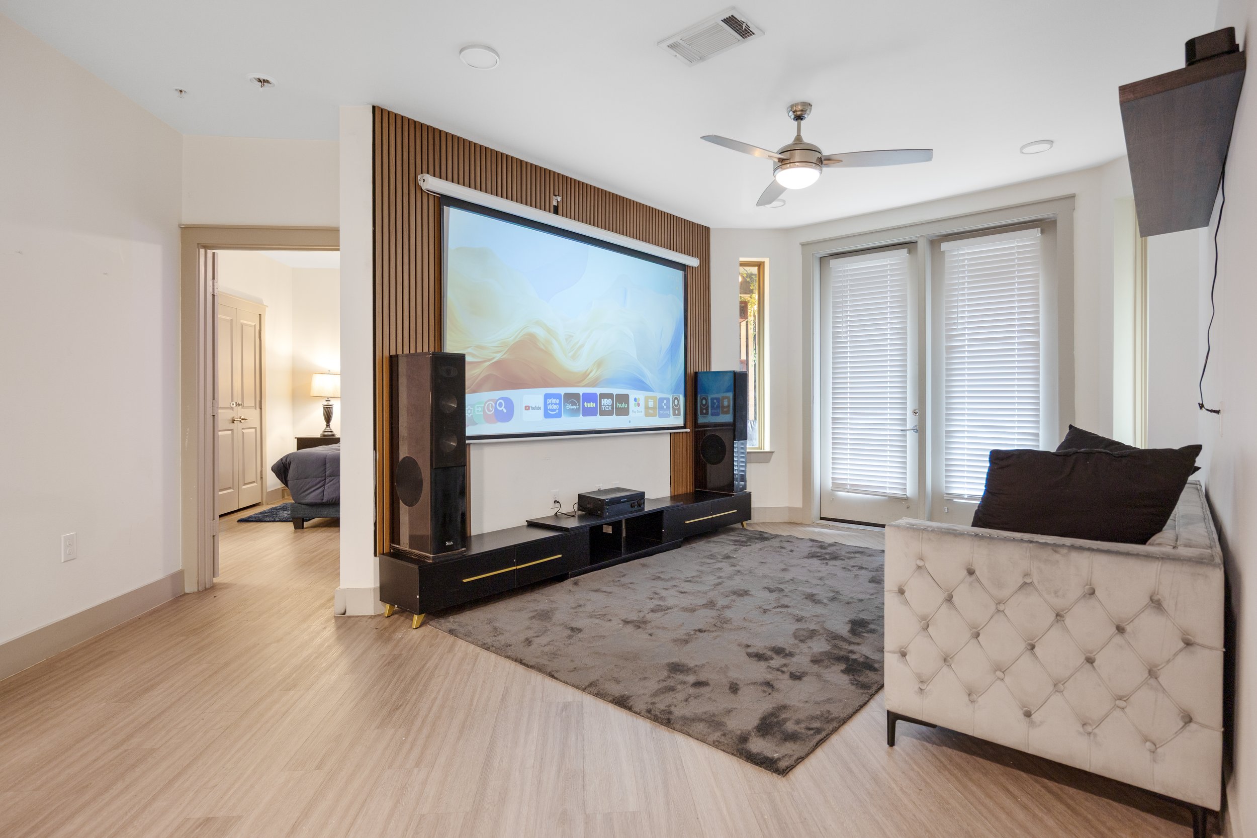 Short-term rental living room with large screen entertainment setup and open layout for guest enjoyment