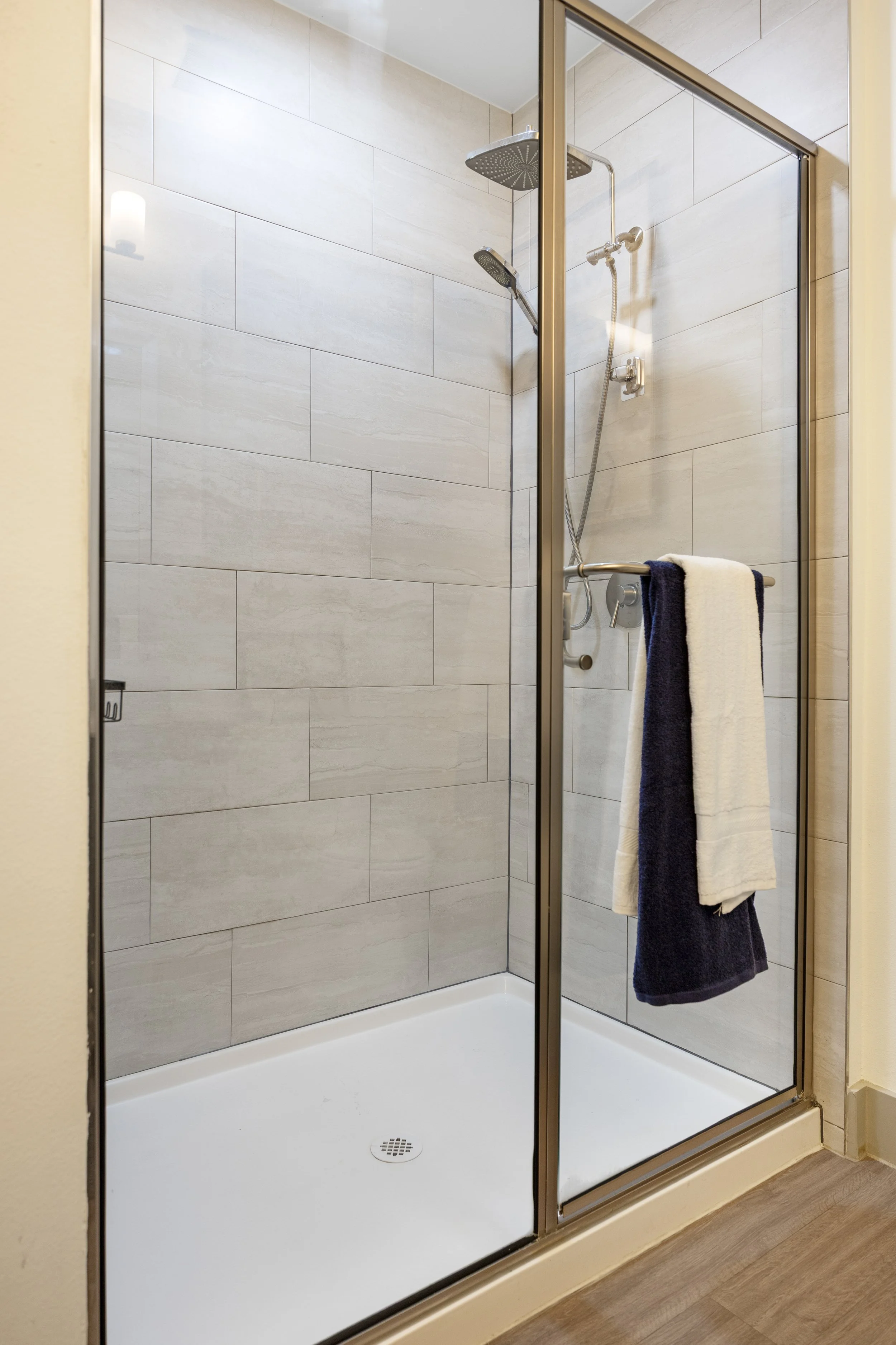 Walk-in glass shower with tiled walls and modern fixtures in a short-term rental bathroom