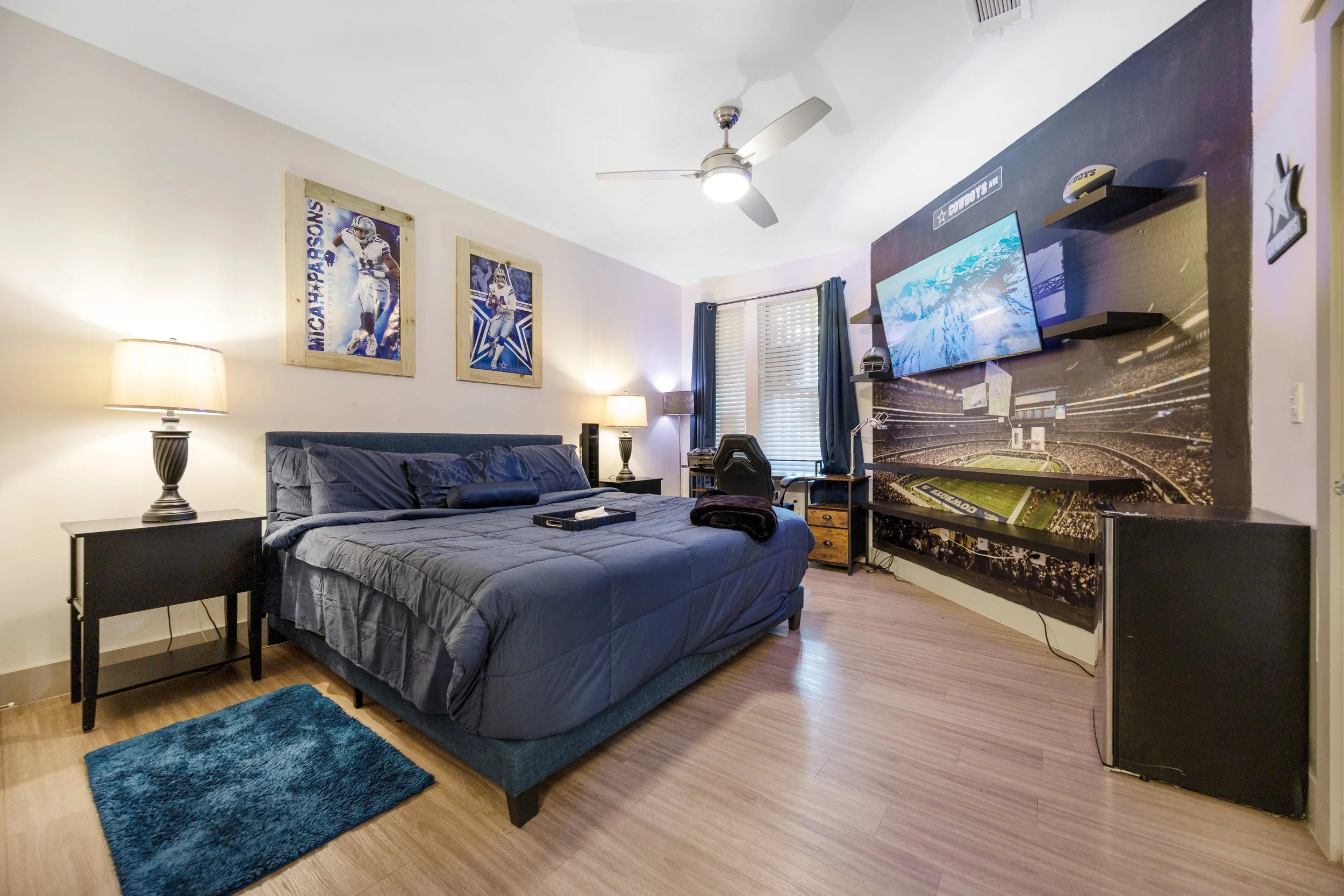 Short-term rental bedroom with large TV, workspace, and comfortable layout designed for extended stays