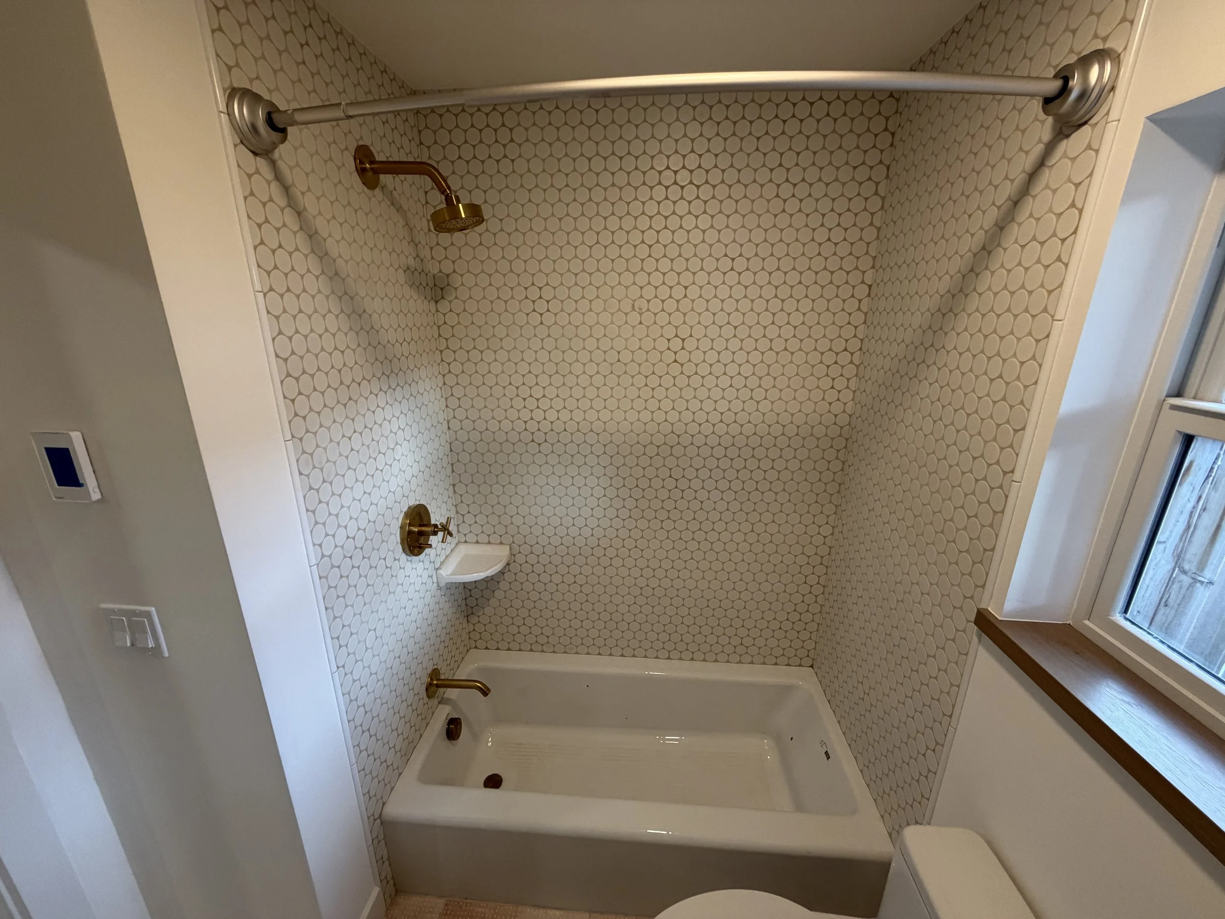 New main level full bathroom with tile tub surround