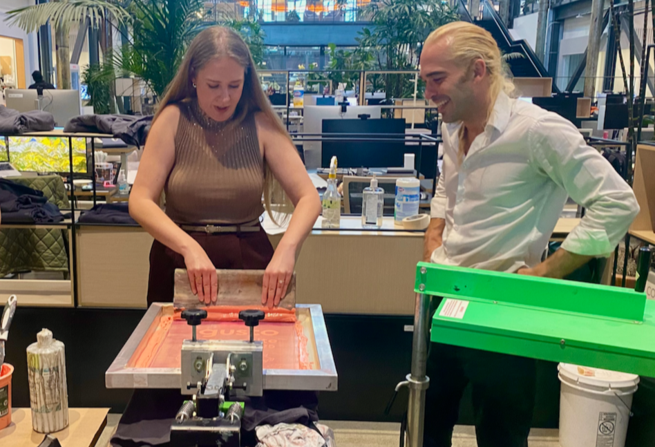 Woman holding a squeegee at a mobile printing press