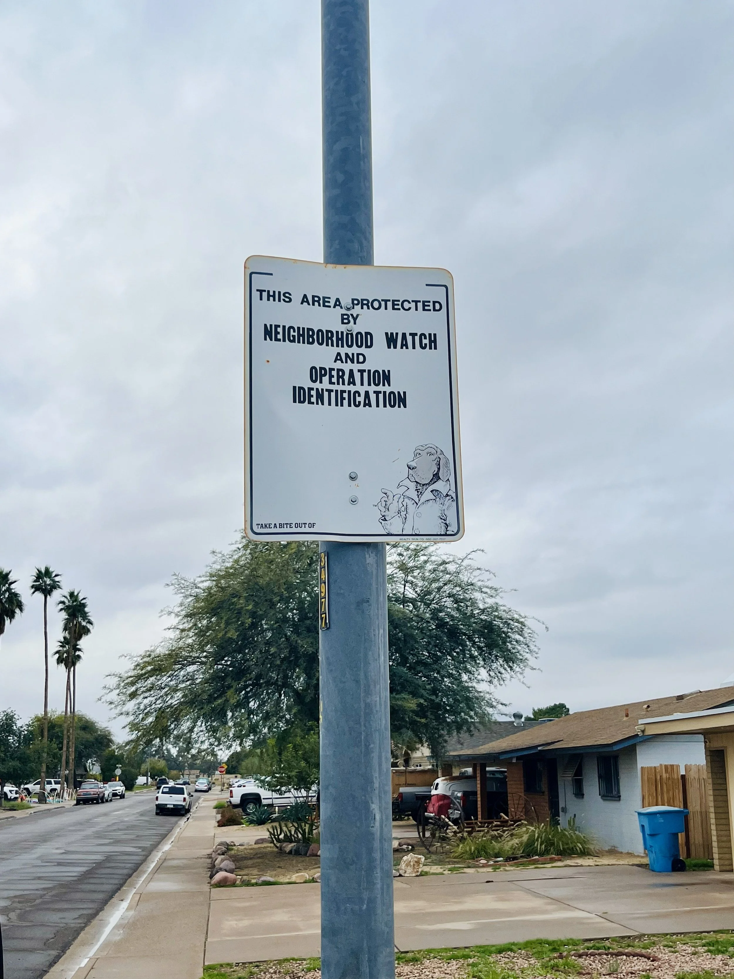 old faded and rusty block watch sign featuring McGruff the crime dog.