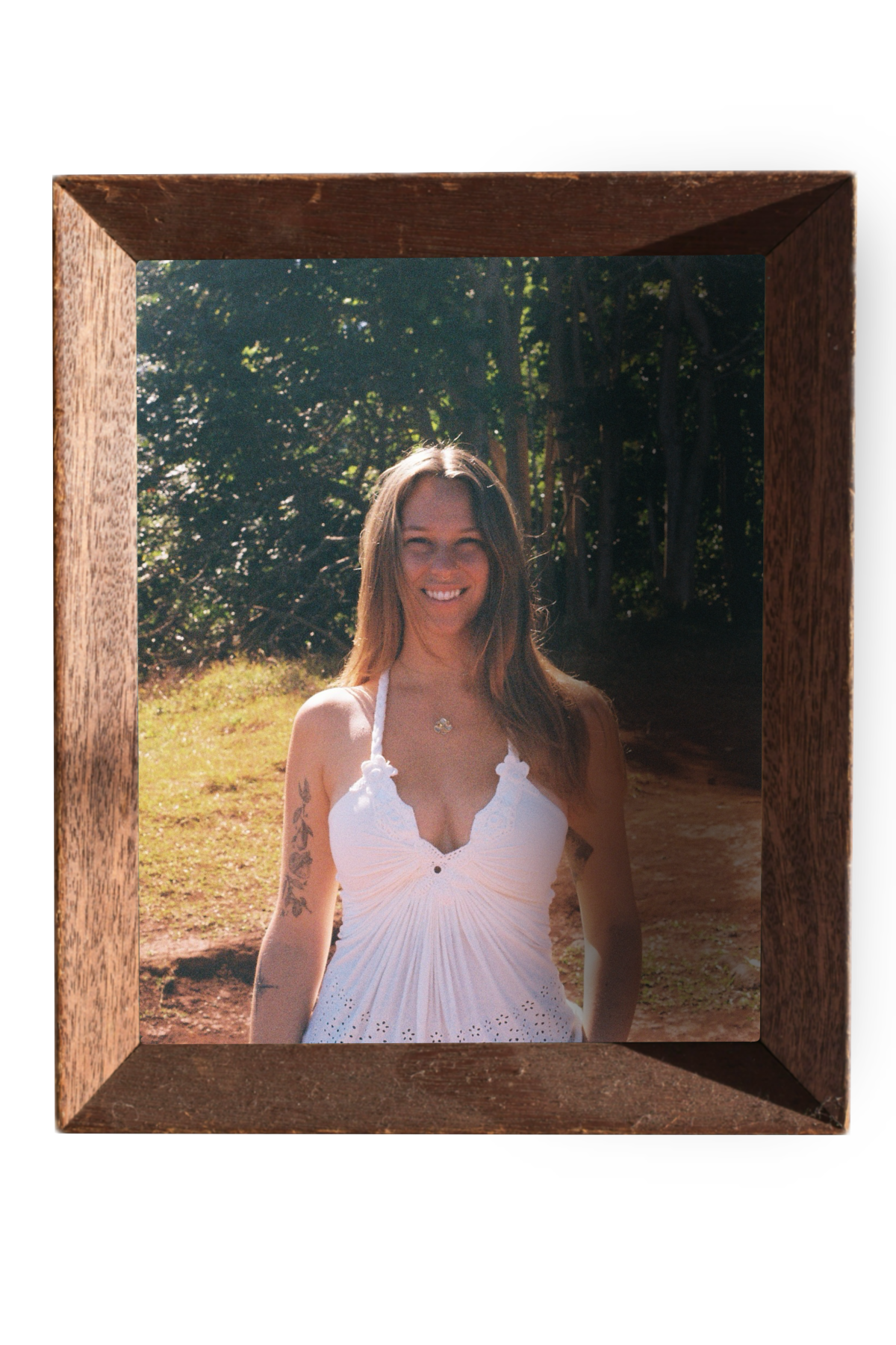 35mm film portrait of Sarah Madore smiling in a lush green forest. Framed by an old wooden picture frame.