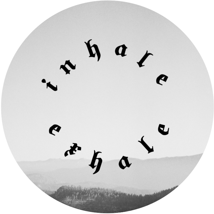 Black and white film photo of mountains with the words "inhale exhale" written in a circle