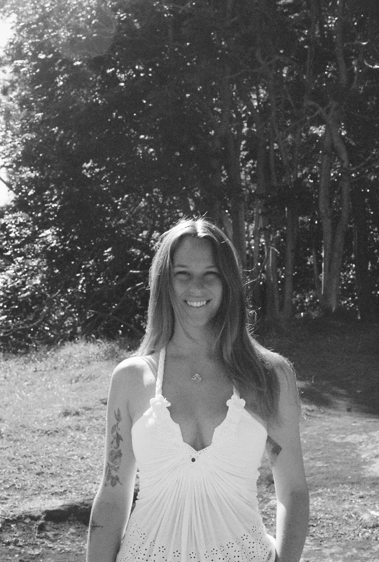 Black and white portrait taken outside in front of trees