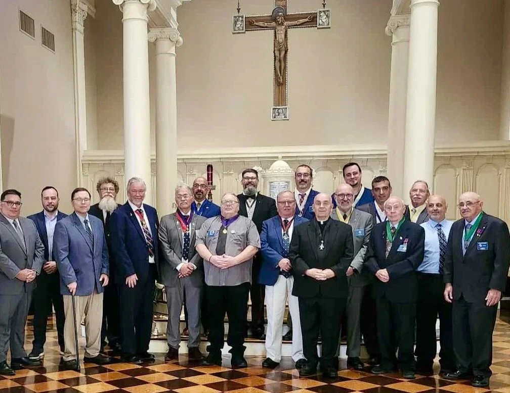 Group of men dressed in formal attire standing inside a church with a crucifix on the wall behind them.