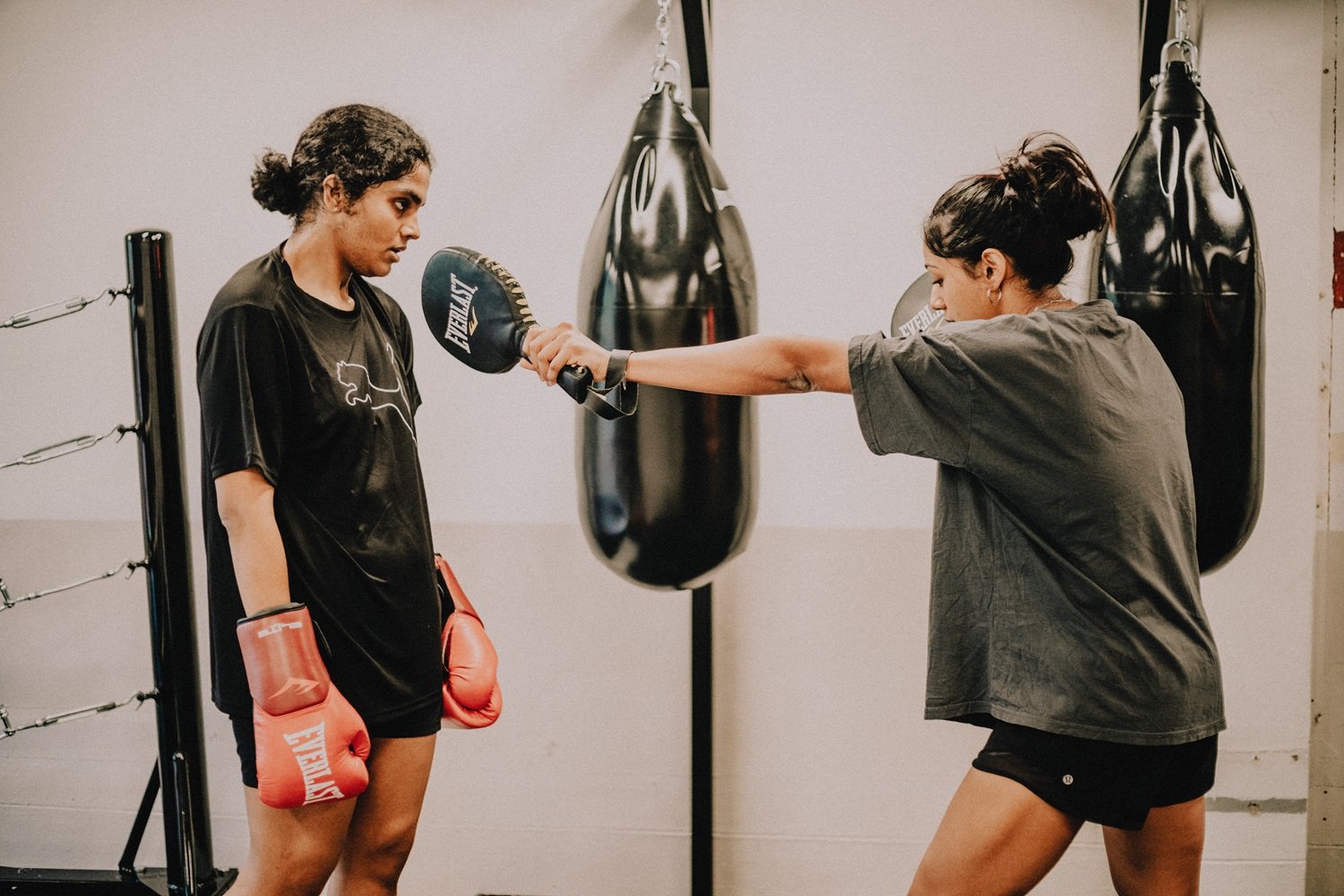 Two women doing boxing pad work drill at Sweat Science Studio, Clarke Quay Singapore CBD