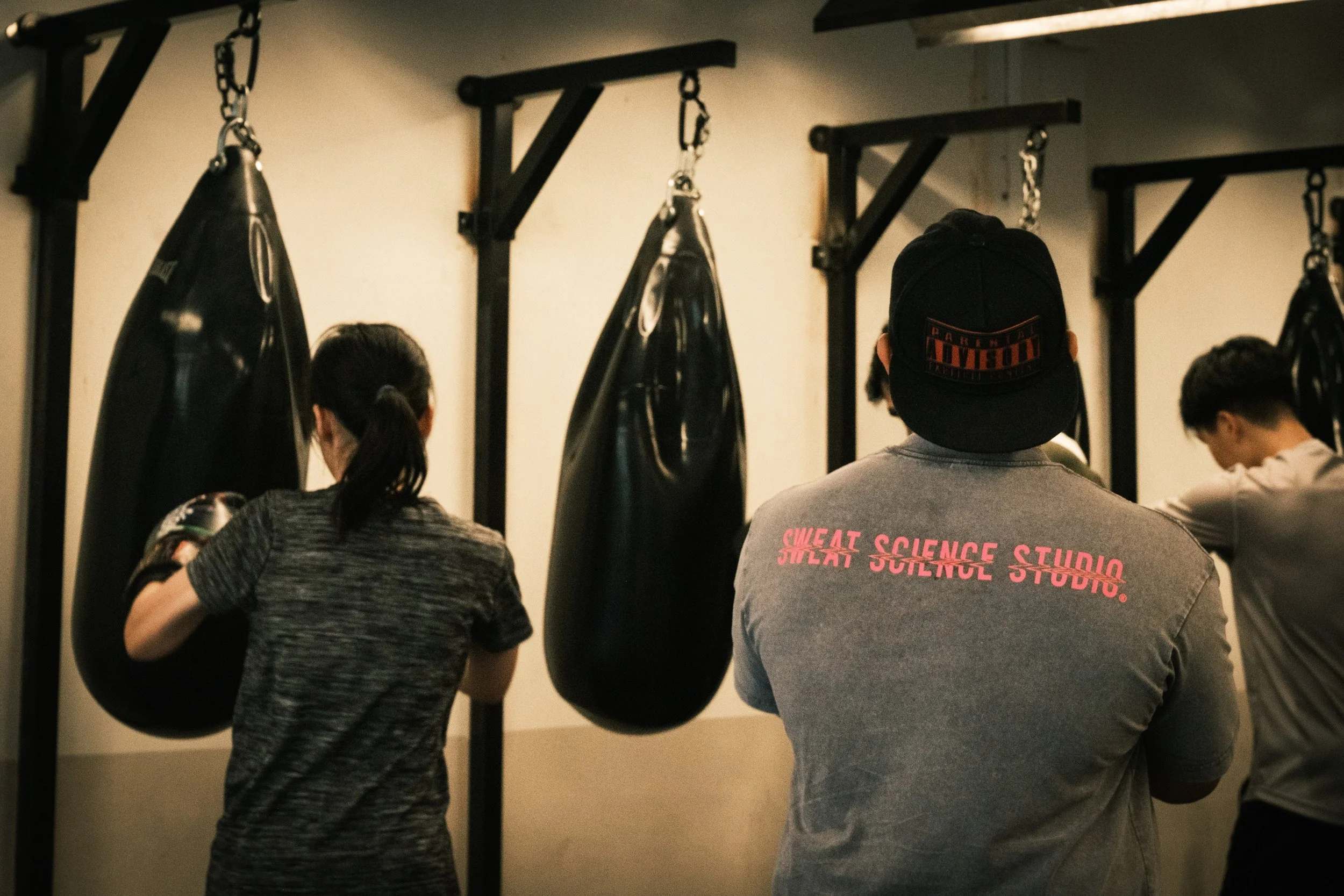 Members training on hanging heavy bags at Sweat Science Studio boxing gym in Clarke Quay, Singapore