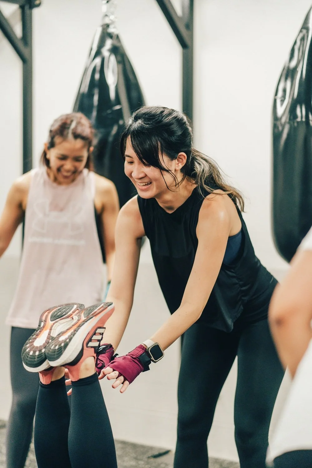 Two women laughing after a boxing workout at Sweat Science Studio, boutique boxing gym Singapore