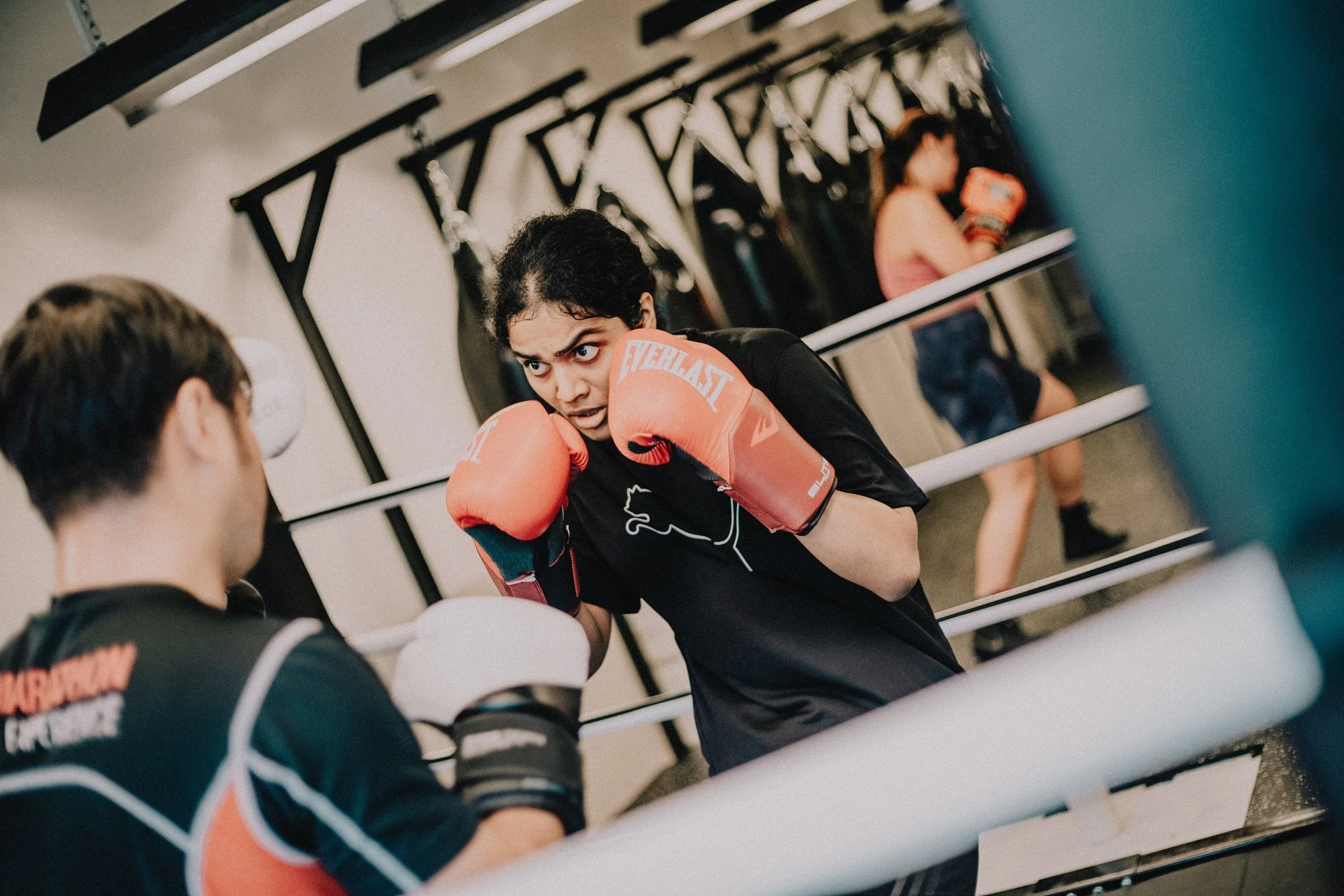Woman in boxing gloves in fighting stance during a women's boxing class at Sweat Science Studio, Singapore