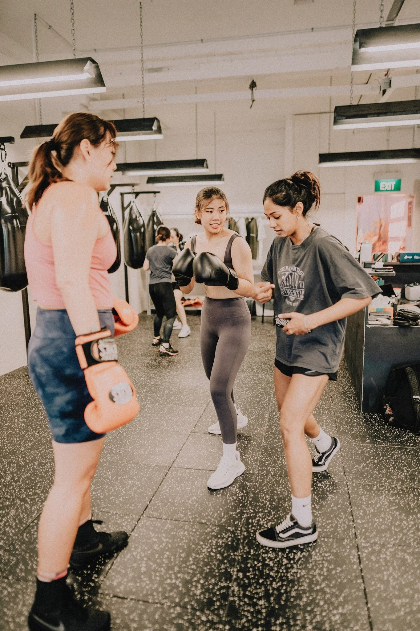 Women's boxing class at Sweat Science Studio, Clarke Quay CBD Singapore — beginners learning technique with gloves