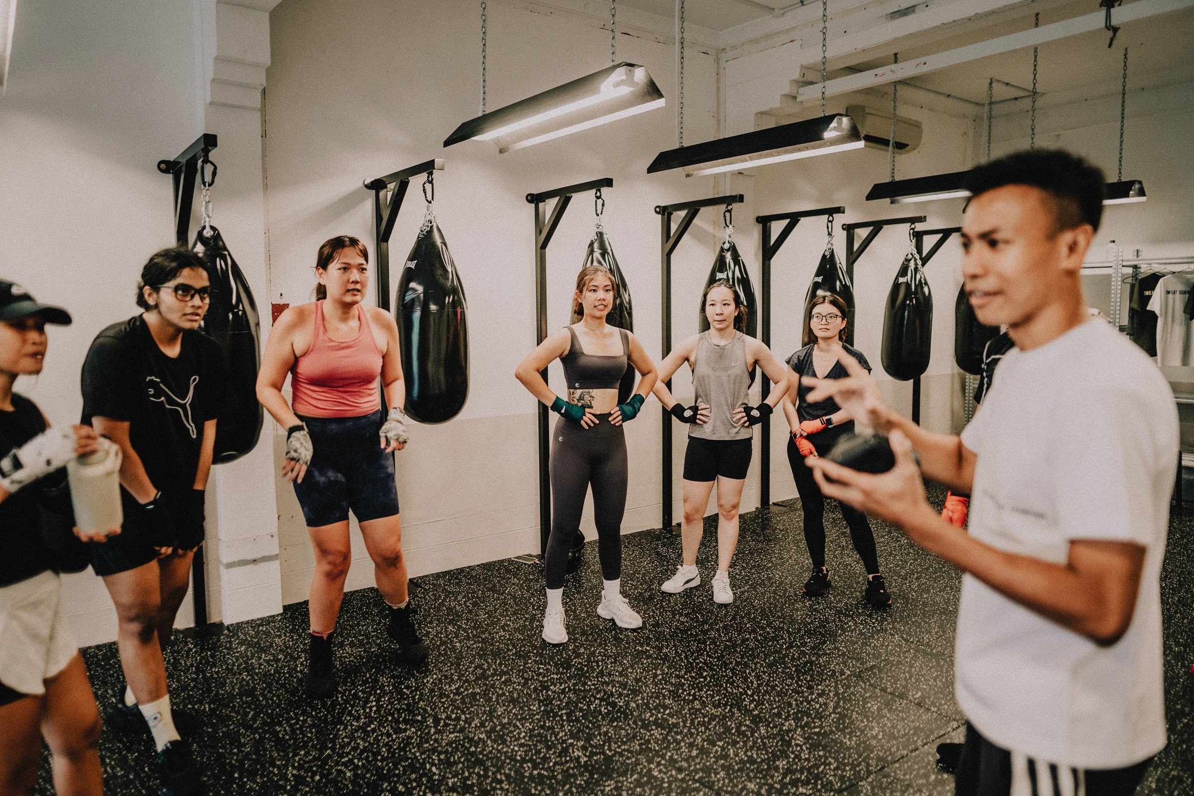 Professional boxing coach in fighting stance with gloves at Sweat Science Studio Singapore, home for everyday champions