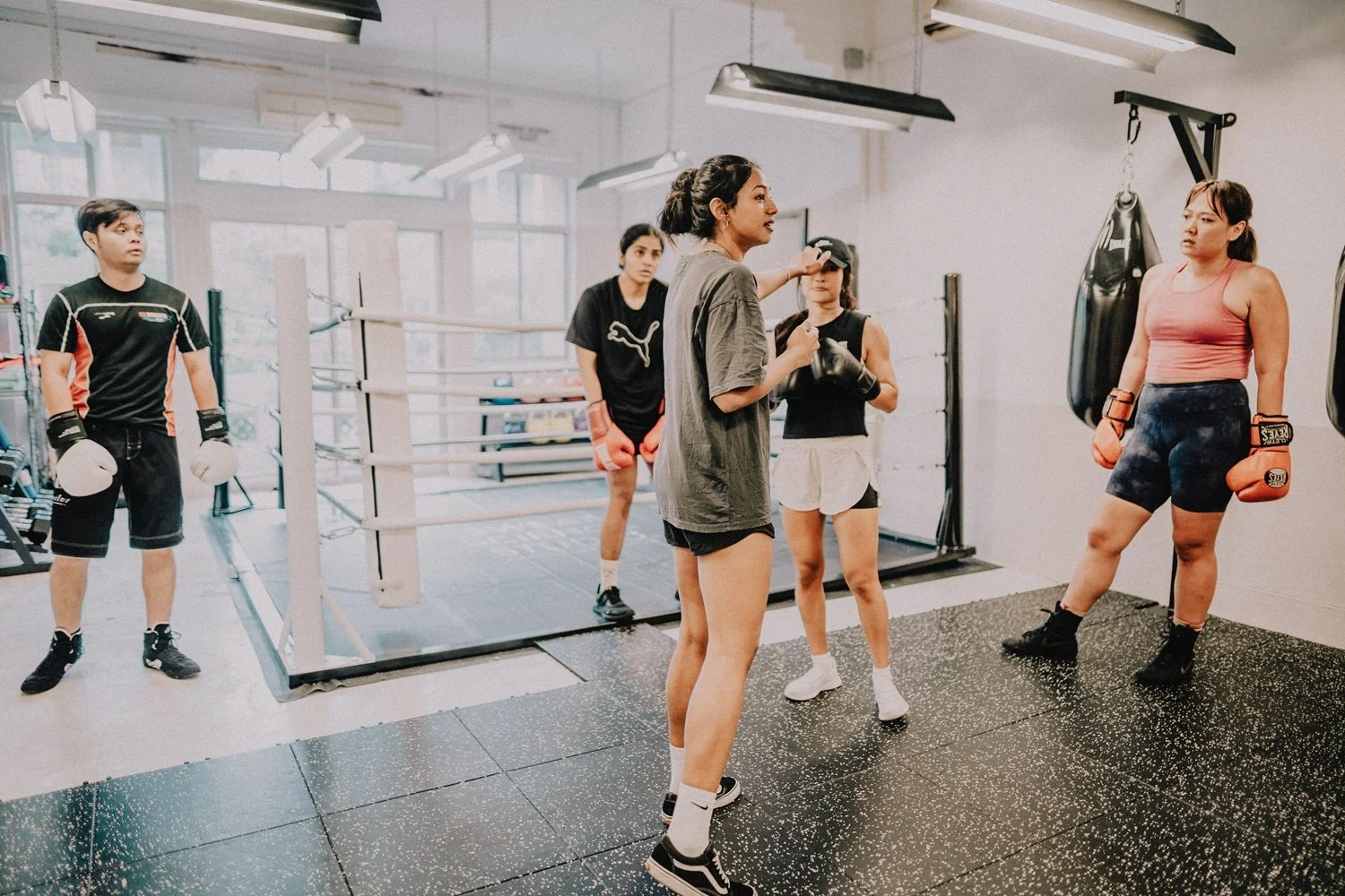 Boxing technique instruction during a group class at Sweat Science Studio boutique boxing gym, Singapore CBD