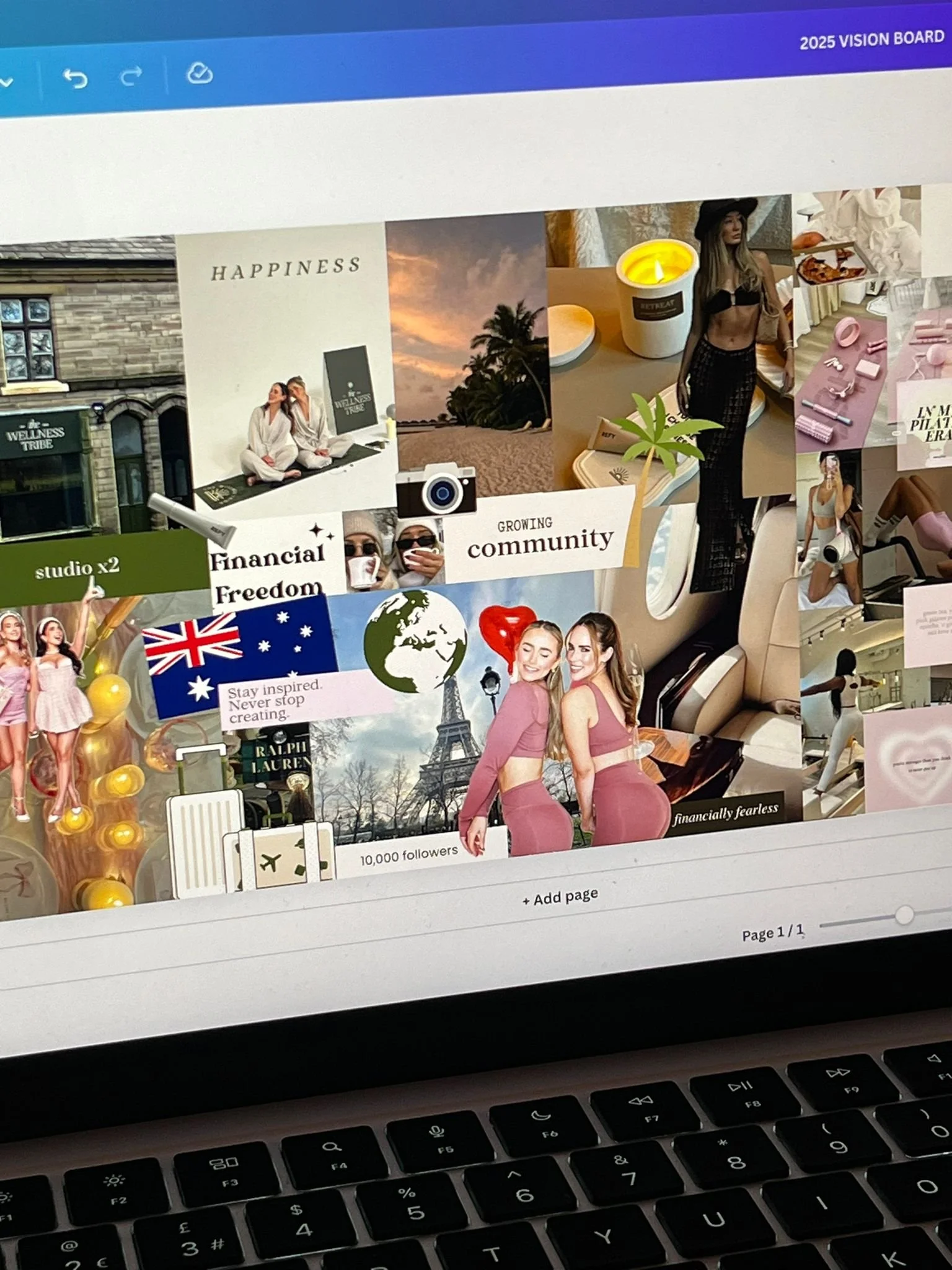 A digital vision board displayed on a computer screen featuring images and words such as happiness, community, financial freedom, travel, fashion, and scenic backgrounds, including the Eiffel Tower and sunset. The board also includes icons like the Australian flag, a globe, a camera, and decorative elements like plants and candles.