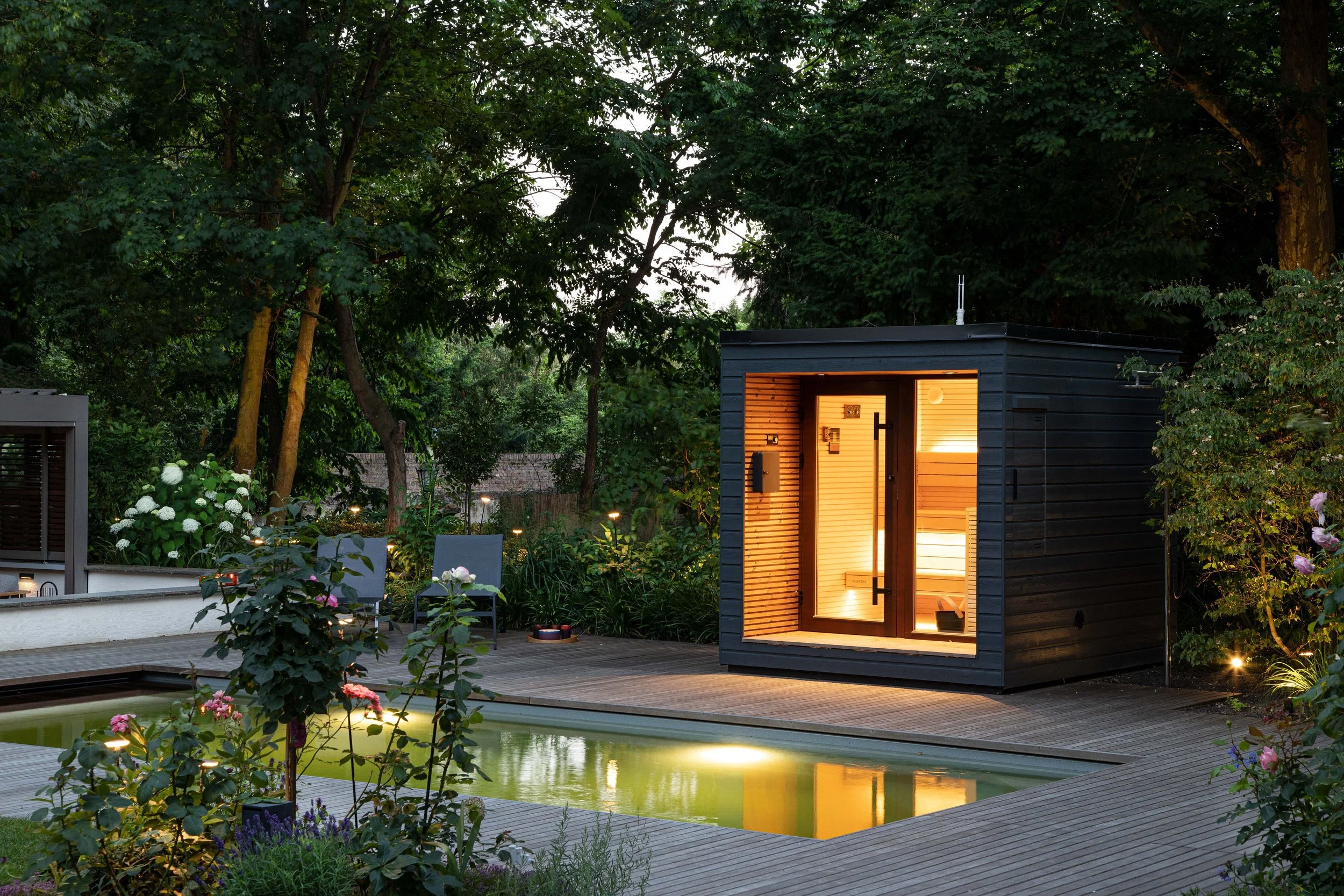 Stimmungsvoll beleuchteter Poolgarten mit Sauna im Rheingau