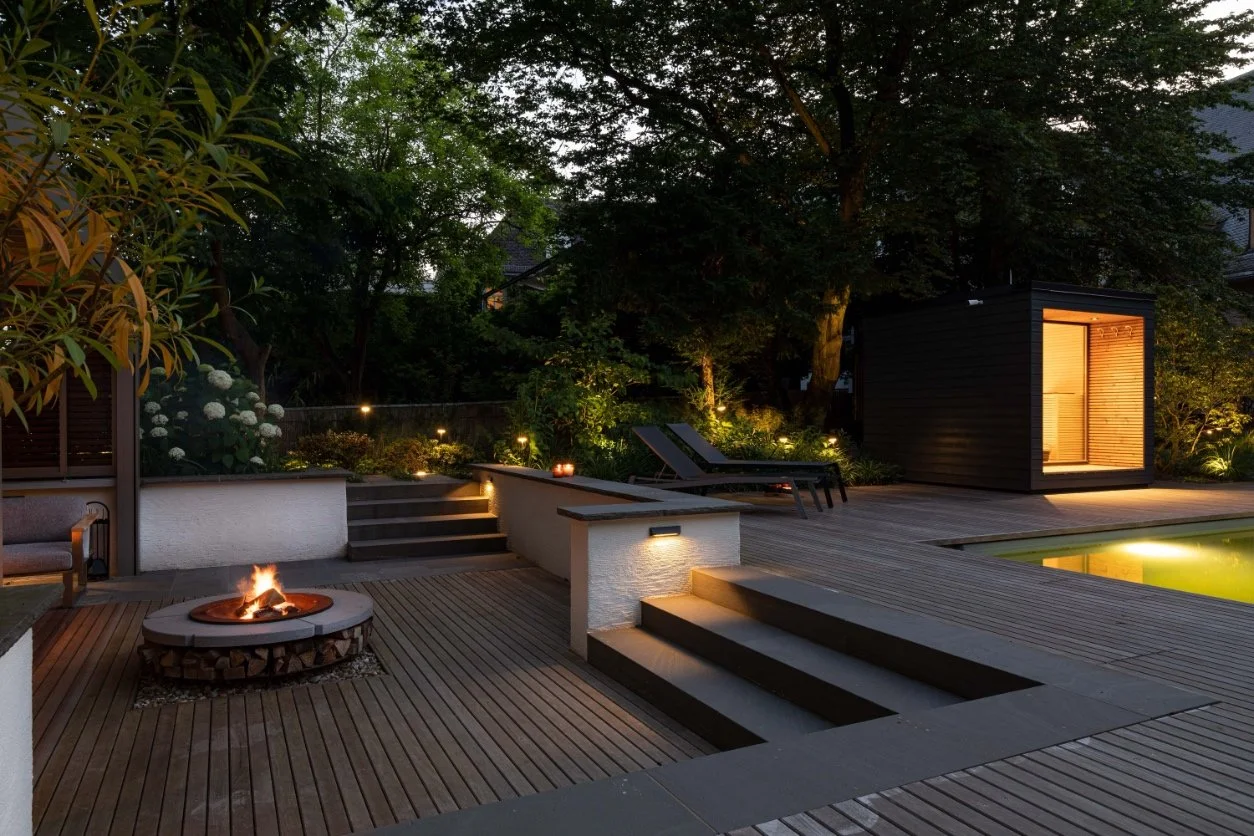 Garten mit Feuerstelle und stimmungsvoller Abendbeleuchtung