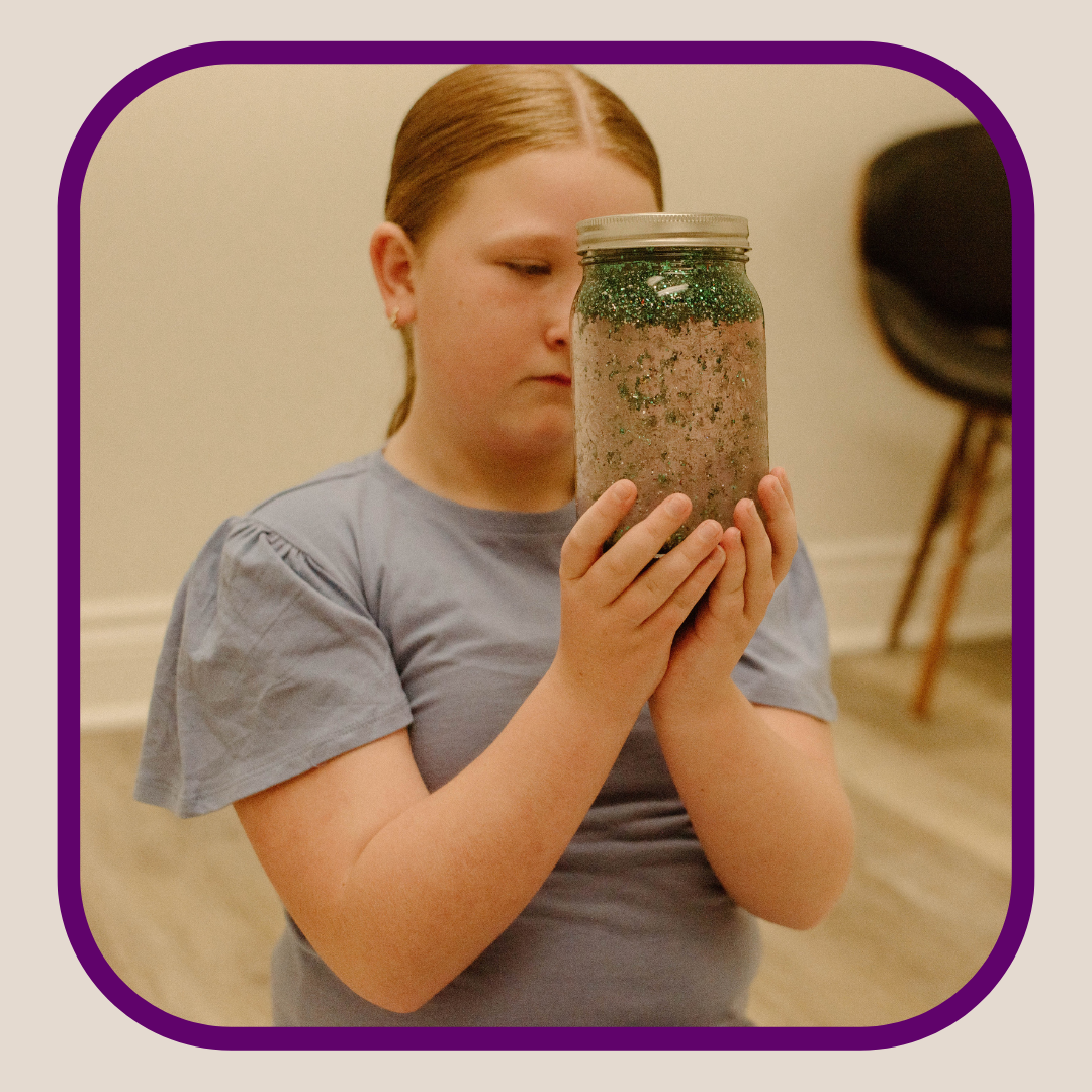 Child using a mind jar tool for calming the mind and being present in the moment.