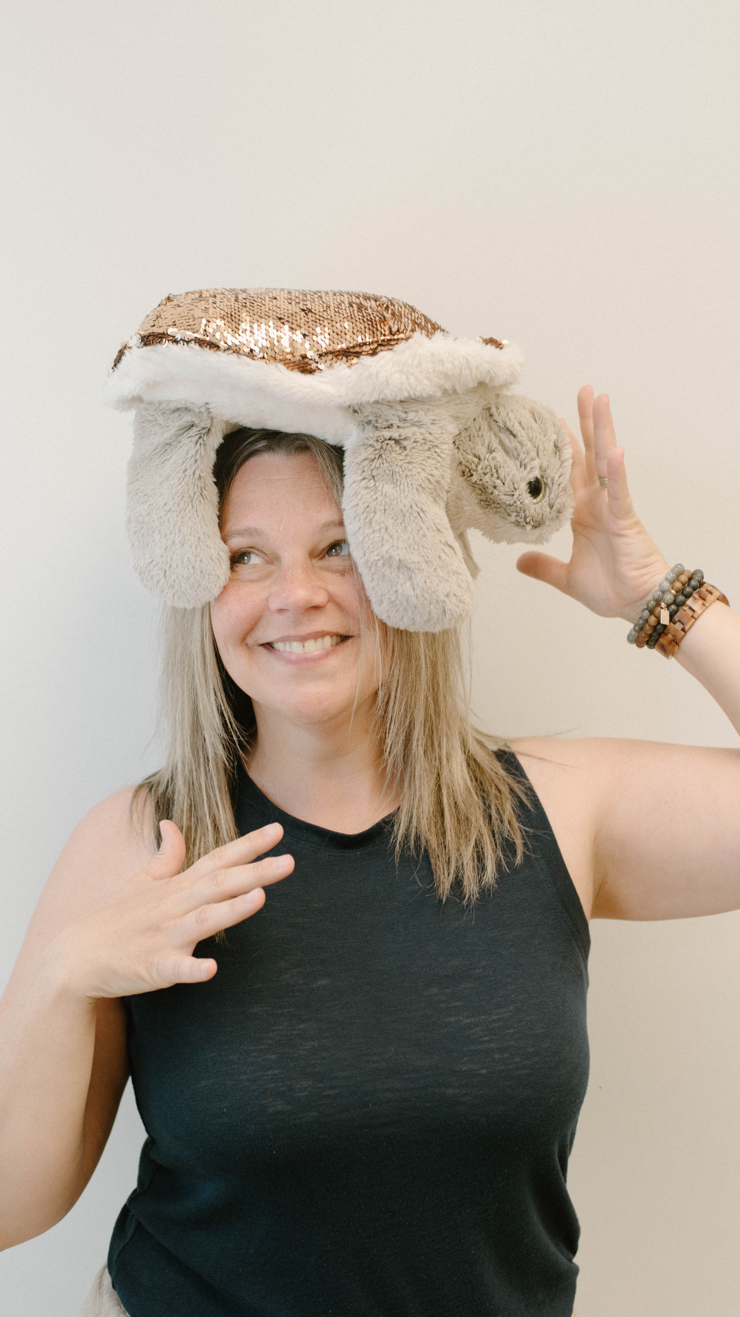 CEO Melissa of Mindful Kids Inc. playfully engaging attention with a sea turtle stuffed animal on her head.