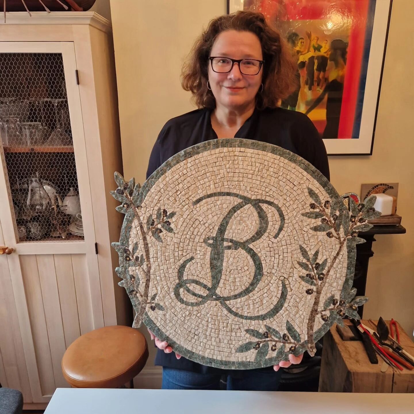 The logo mosaic for @basilleafdeli is finished! I love making olive branches. They share a rough beauty and strength and sense of the ages with riven cut marble, don't they? Shout out to Lawrence from @romanmosaics for the marble. #mosaic #marble #ol