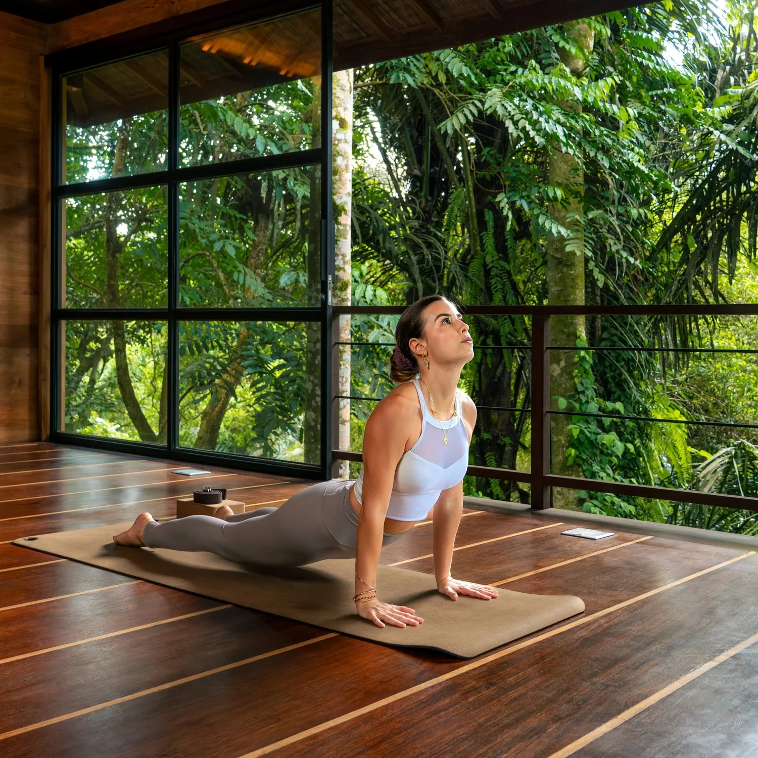 Audrey in upward-facing dog in a wooden jungle studio