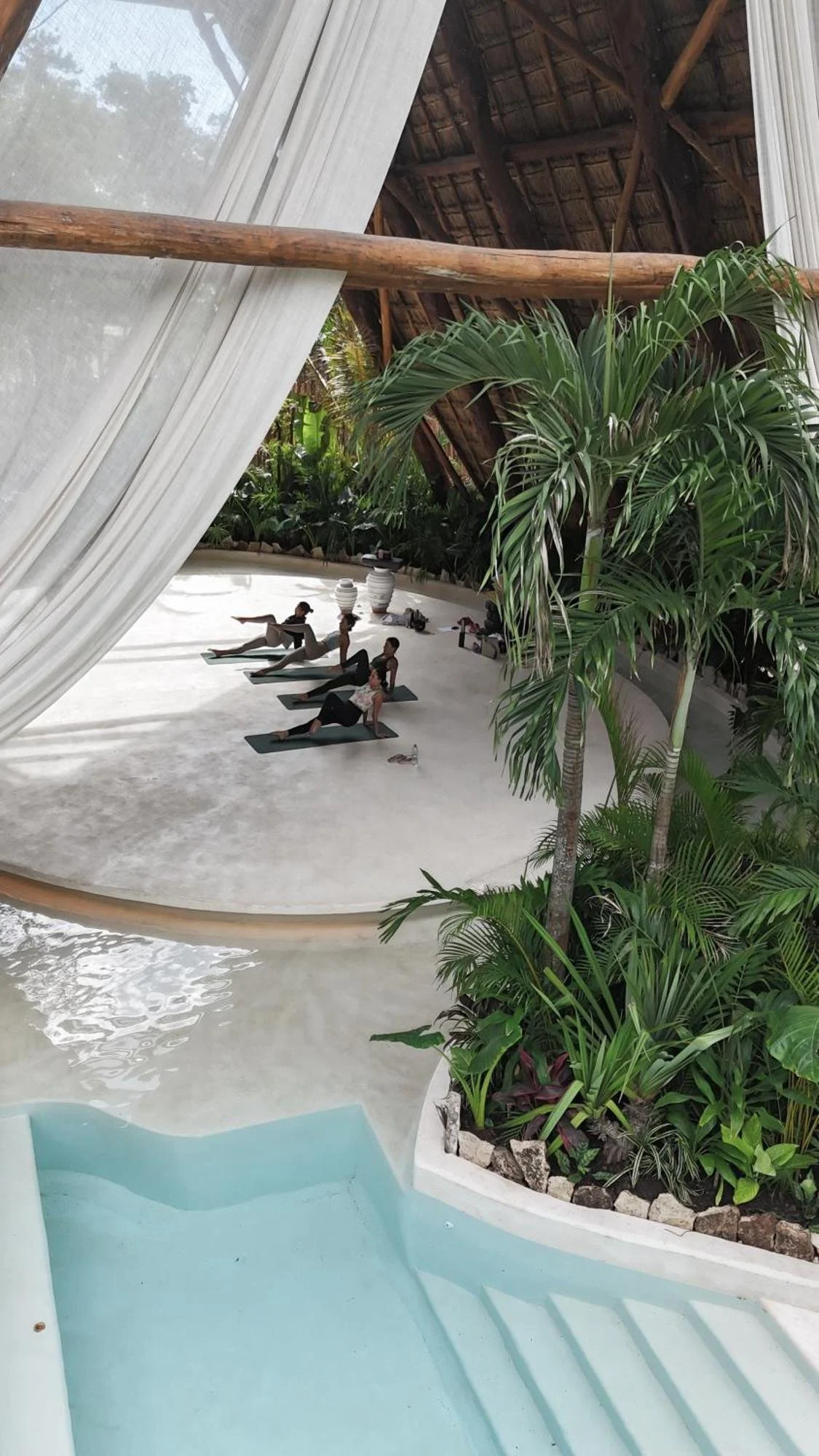 A wellness class on a white terrace at Hotel Milam, Tulum