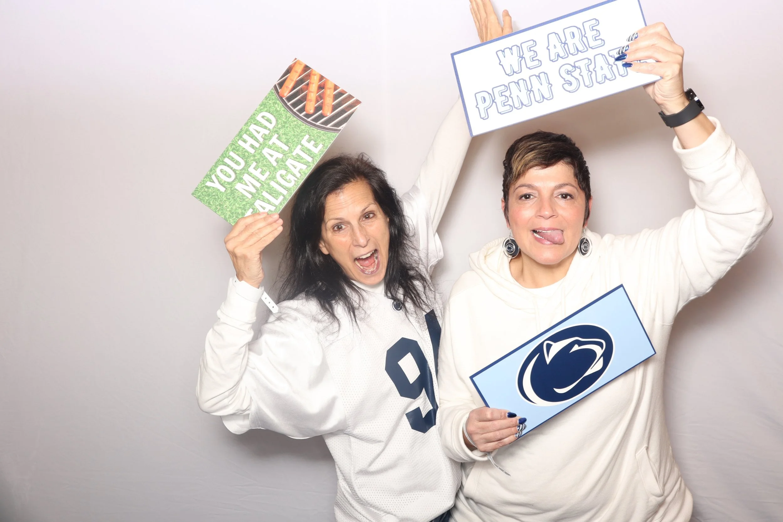 Penn State University moms having fun using custom props with white satin backdrop