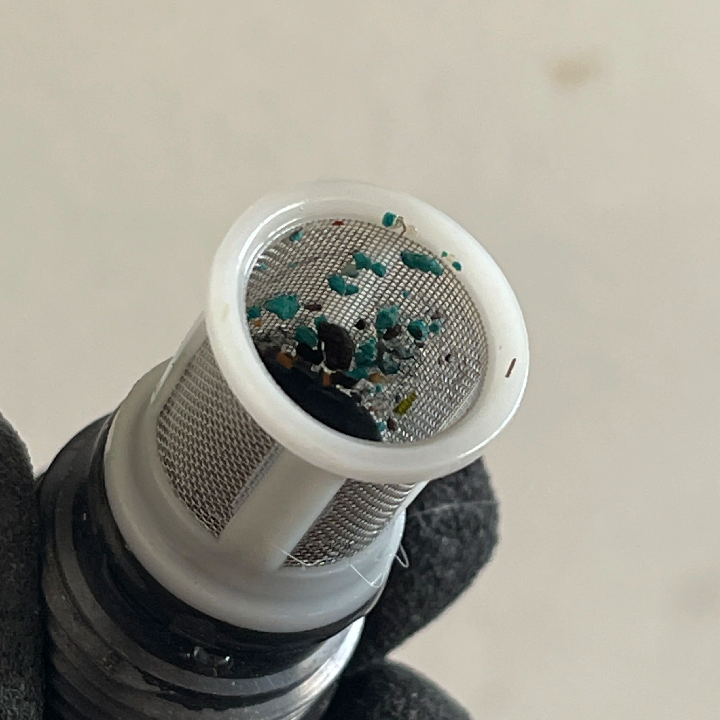 “Clogged Rinnai tankless water heater inlet filter with hard-water debris removed during annual flush.”