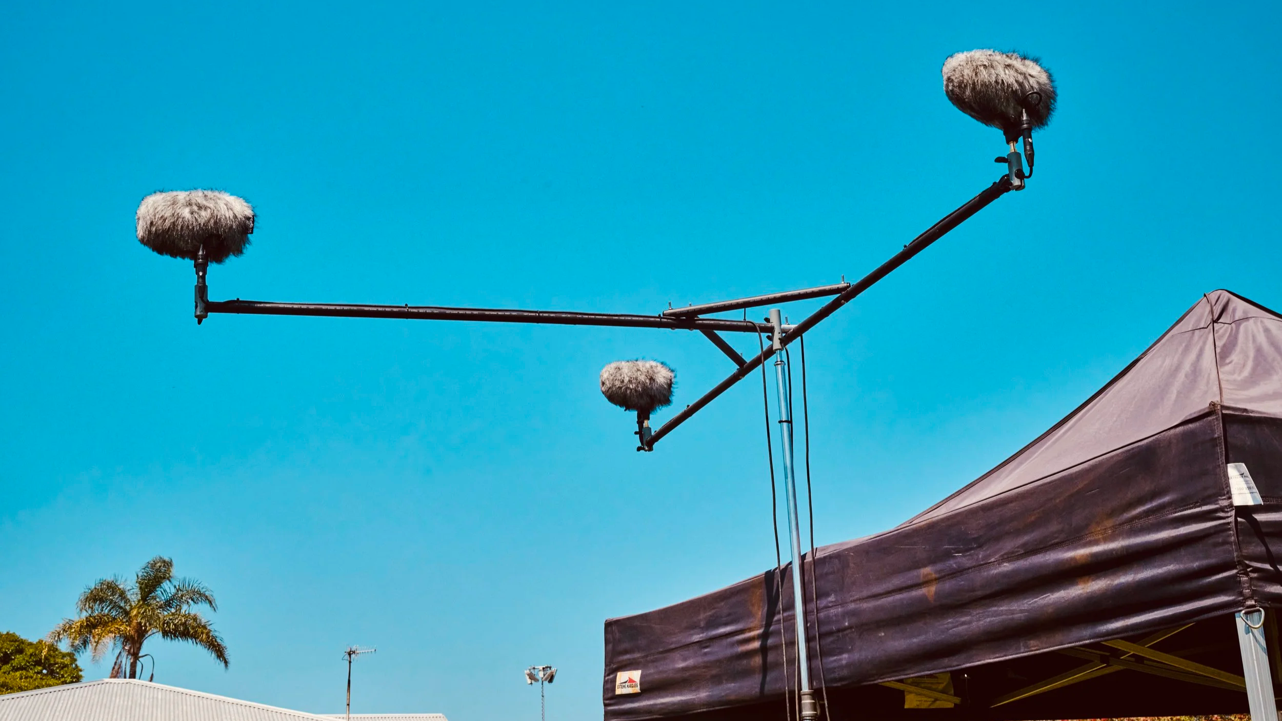 Boom pole with windshield microphone extended over an outdoor film location