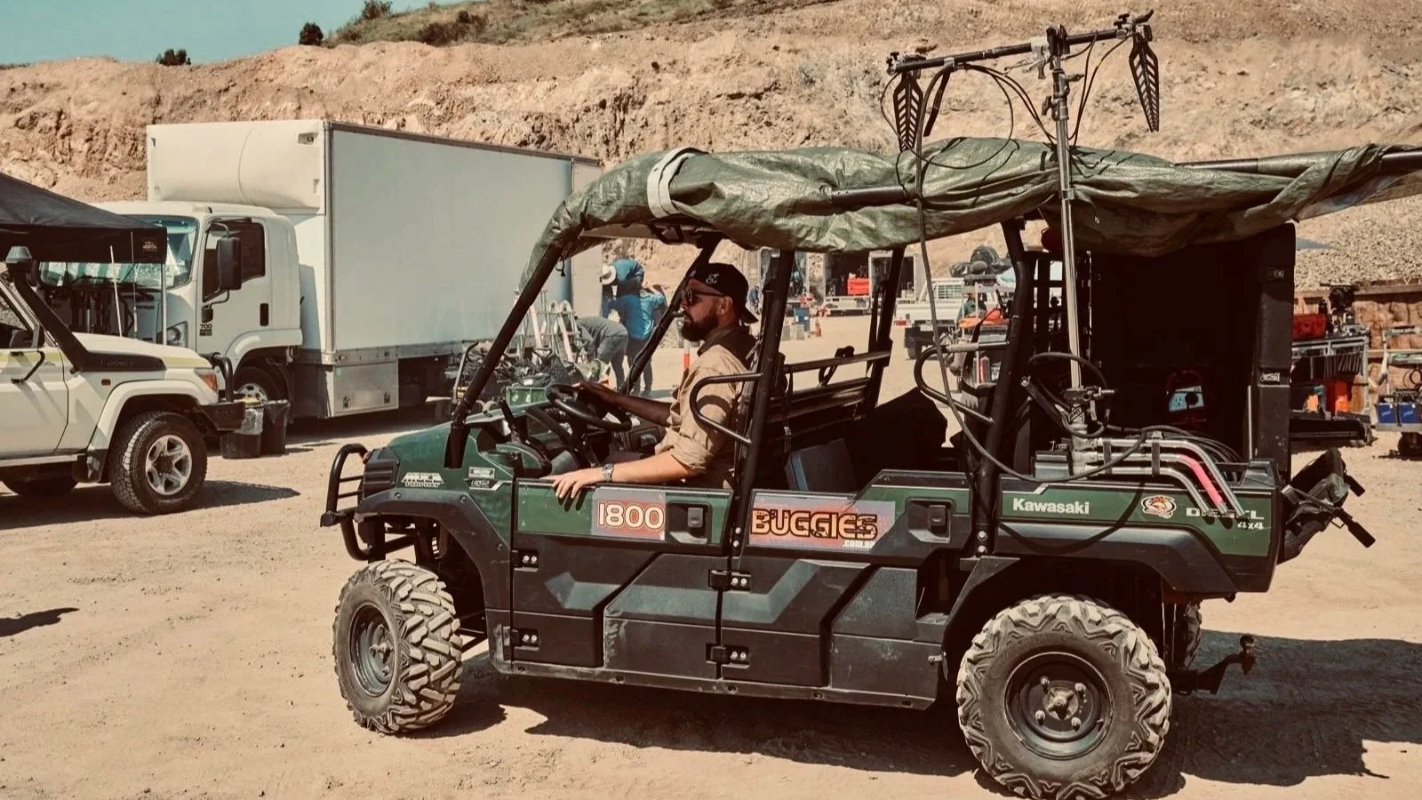 Sound recordist operating audio equipment from a vehicle on a remote outdoor film location