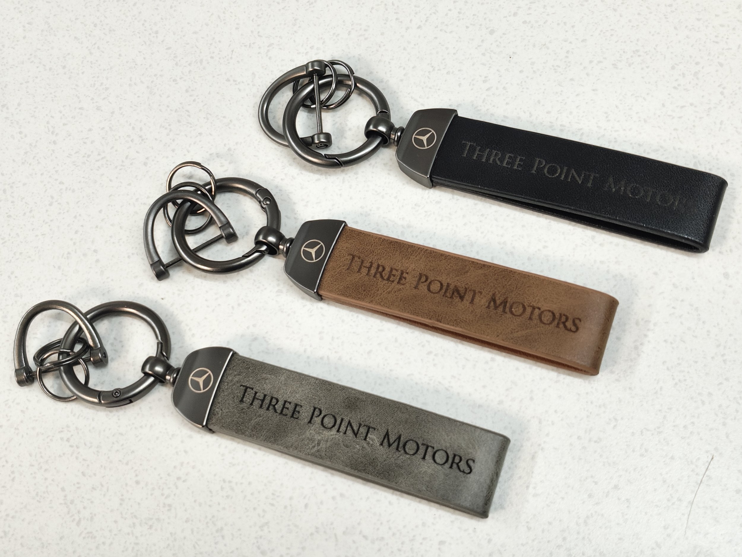 UV laser engraved leather key chains in a variety of colours, including black, grey and brown