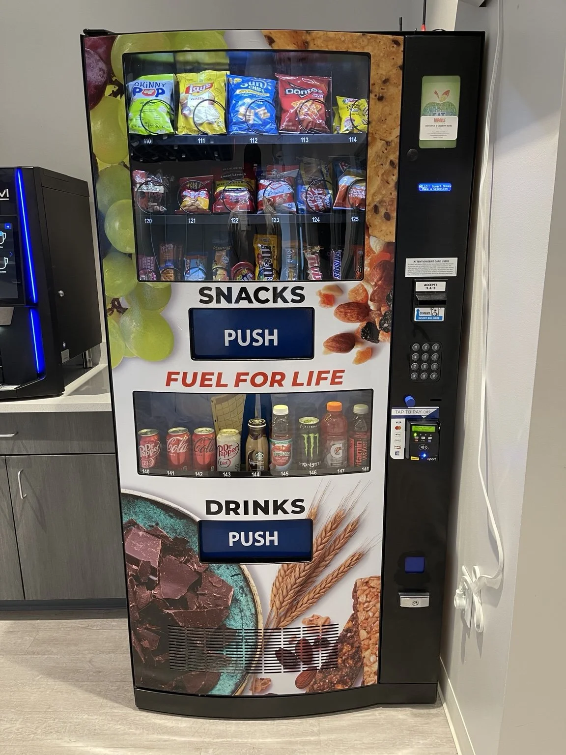 Full snack and drink vending machine with card payment options in a Morrisville workplace.