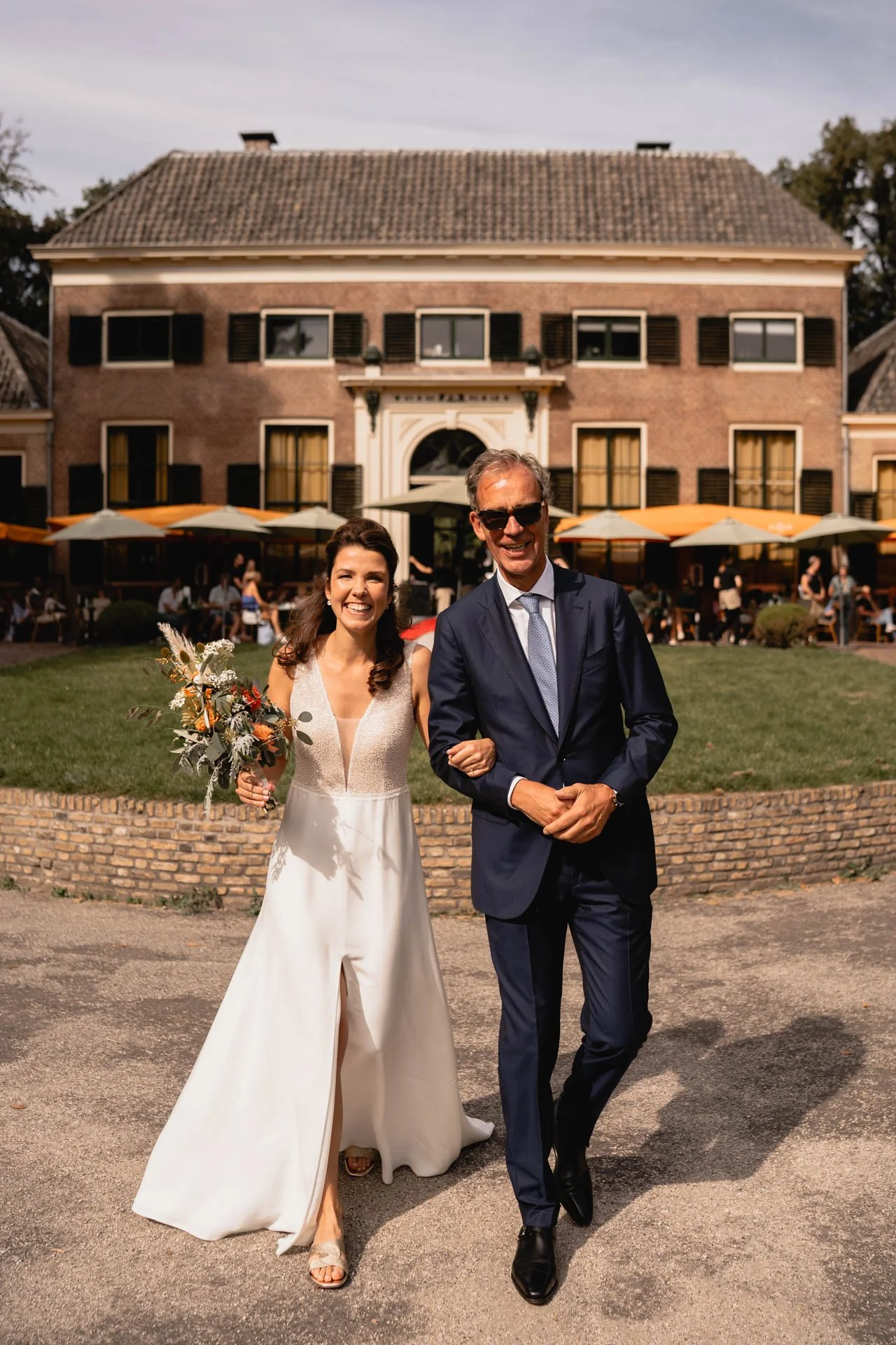 Bruid loopt samen met vader naar de ceremonie bij Dudok in het Park Rotterdam